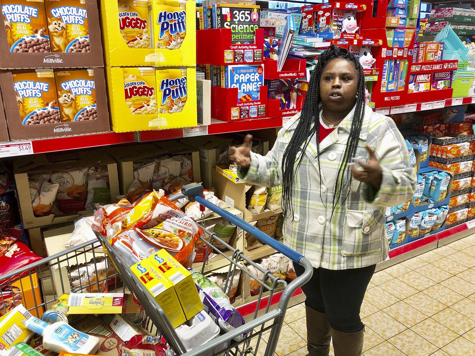In this Sunday, Feb. 10, 2019 photo, Laquesha Russell, a 36-year-old home health care worker who makes $10.78 an hour, speaks during an interview as she shops for groceries for her four children in Springfield, Illinois. (AP Photo / John O’Connor)