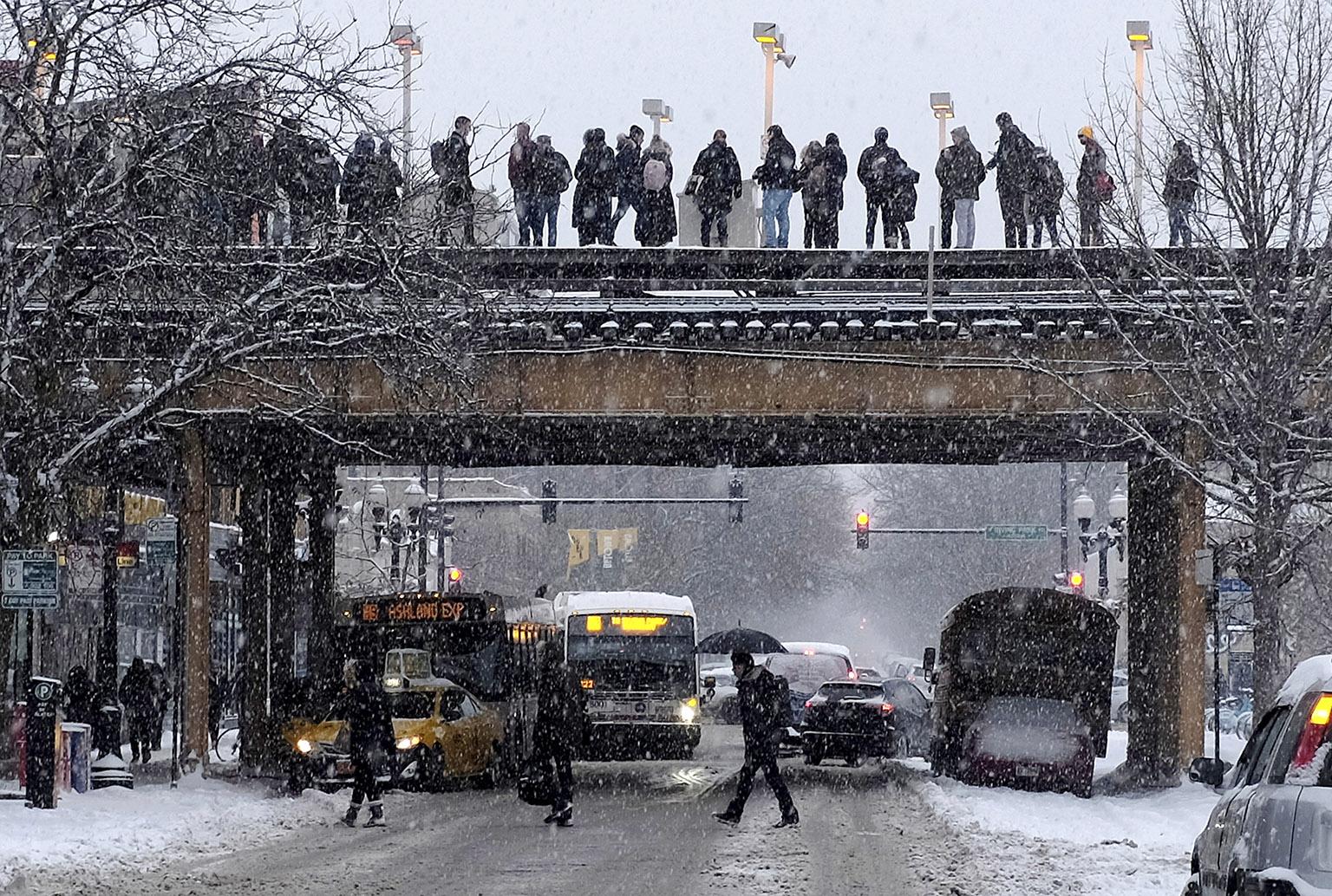 Commuters wait for a train as snow falls Monday, Jan. 28, 2019, in Chicago. (AP Photo / Kiichiro Sato)