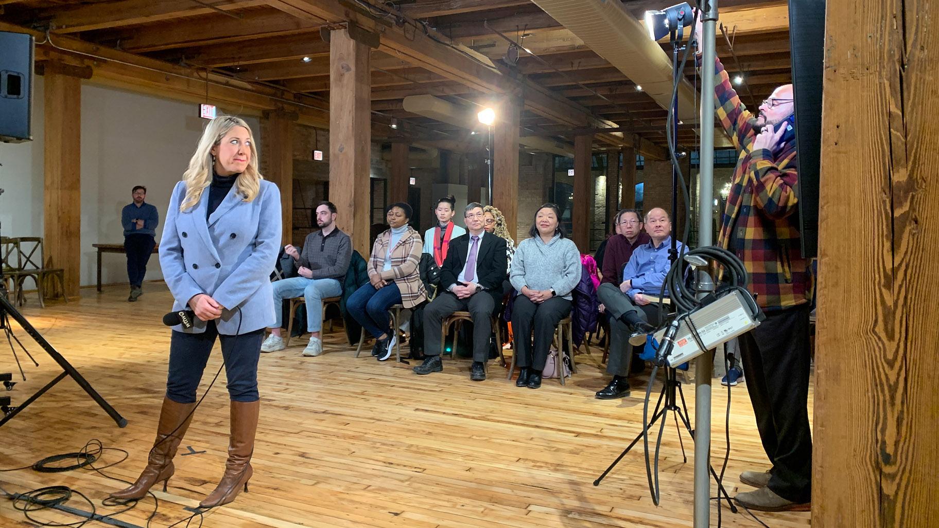 WTTW News correspondent Amanda Vinicky prepares to go live from a WTTW News Mayoral Forum watch event at the Bridgeport Art Center. (Eunice Alpasan / WTTW News)