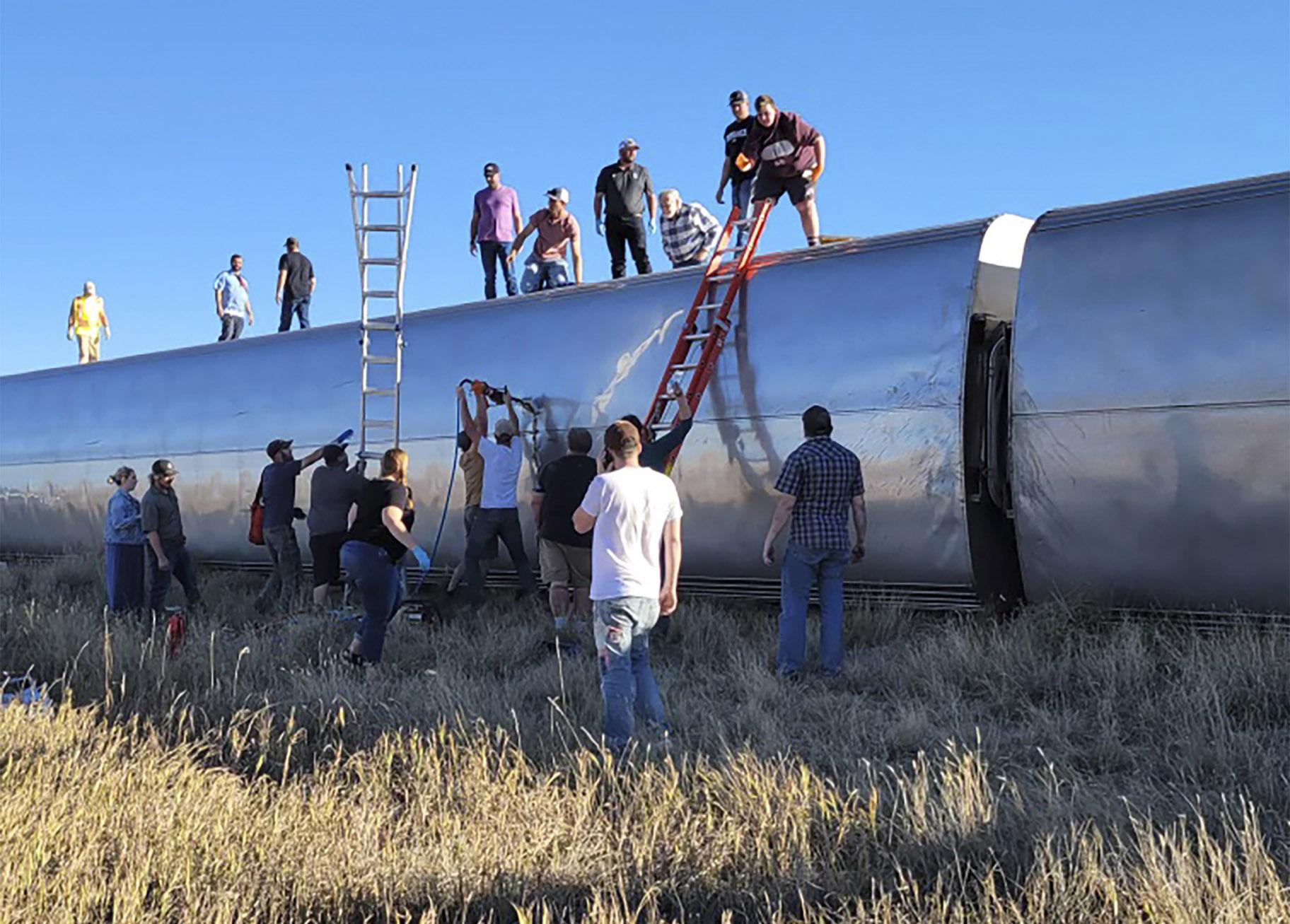 In this photo provided by Kimberly Fossen people work at the scene of an Amtrak train derailment on Saturday, Sept. 25, 2021, in north-central Montana. (Kimberly Fossen via AP)