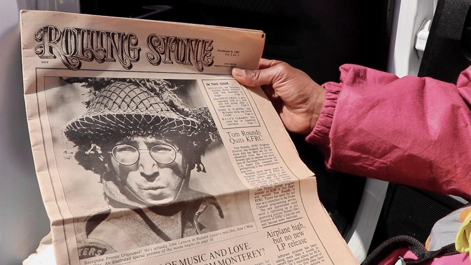 Angel Williams holds what appears to be the first issue of the iconic music magazine Rolling Stone, published in Nov. 1967 and featuring John Lennon on the cover, on April 1, 2022. Williams found the magazine while dumpster diving about a year ago. (Evan Garcia / WTTW News)