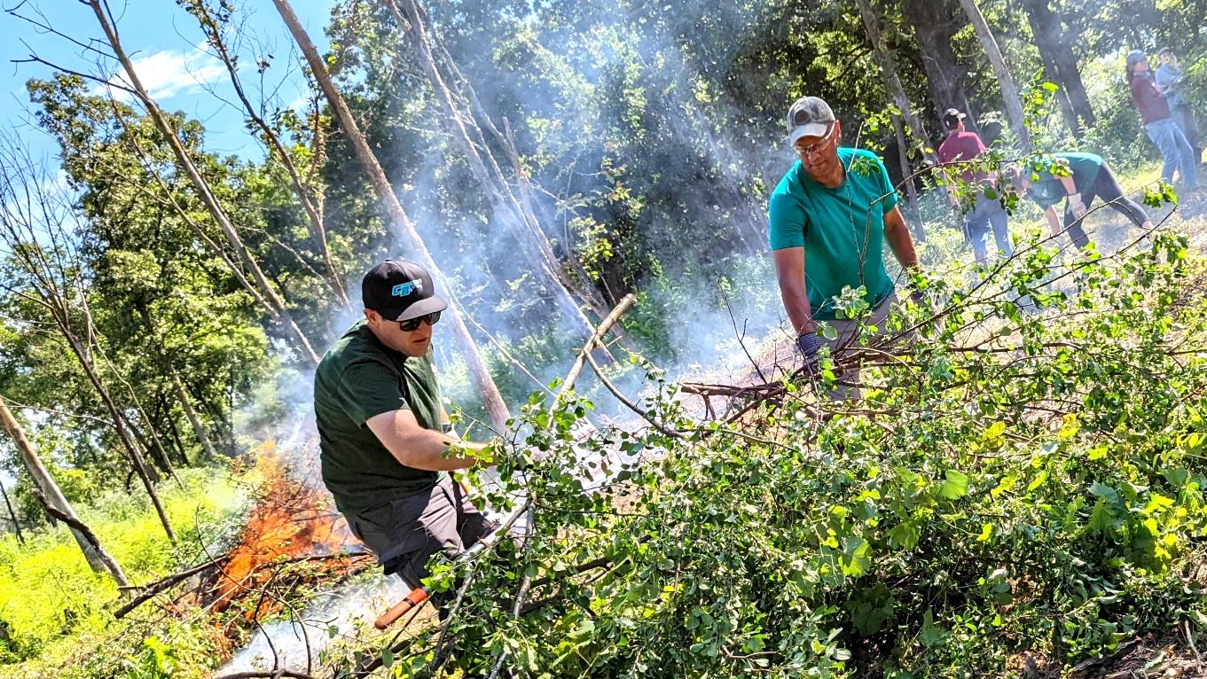 Arnold Randall (r) clearing invasive brush during a restoration workday. (Courtesy Forest Preserve District of Cook County)