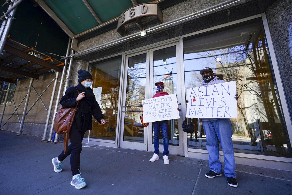 Community activists Calvin, right, and Cameron Hunt show support for the Asian community outside the building where an Asian American woman was assaulted, Tuesday, March 30, 2021, in New York. (AP Photo / Mary Altaffer)