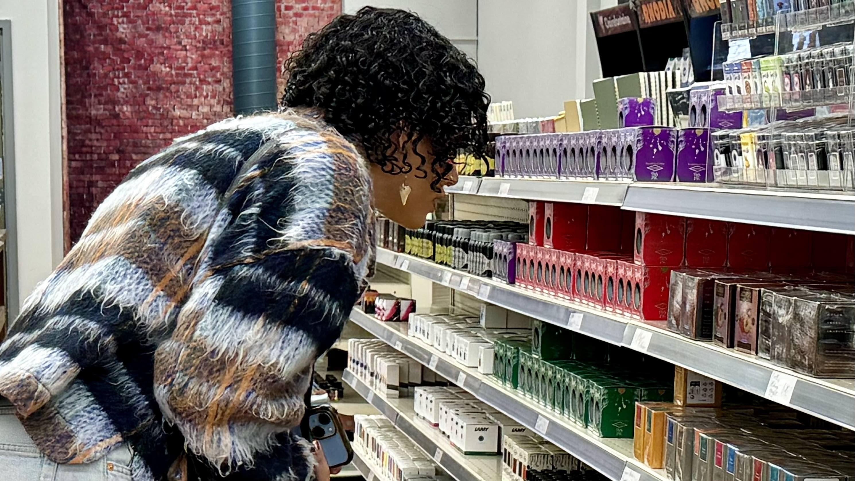 A shopper eyeballs various fountain pen inks at Atlas Stationers. (Patty Wetli / WTTW News)