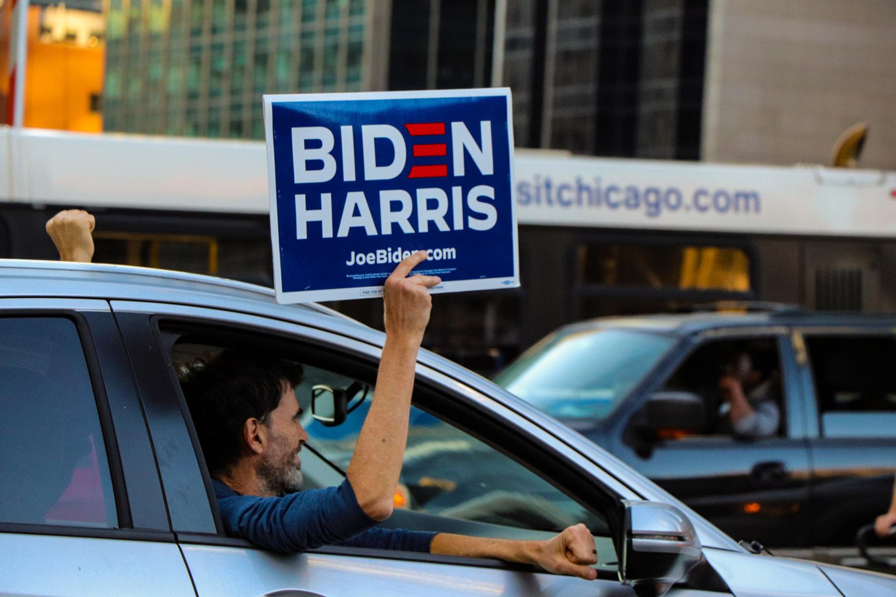 A man holds a Biden Harris sign in Chicago on Saturday, Nov. 7, 2020. (Grace Del Vecchio / WTTW News)