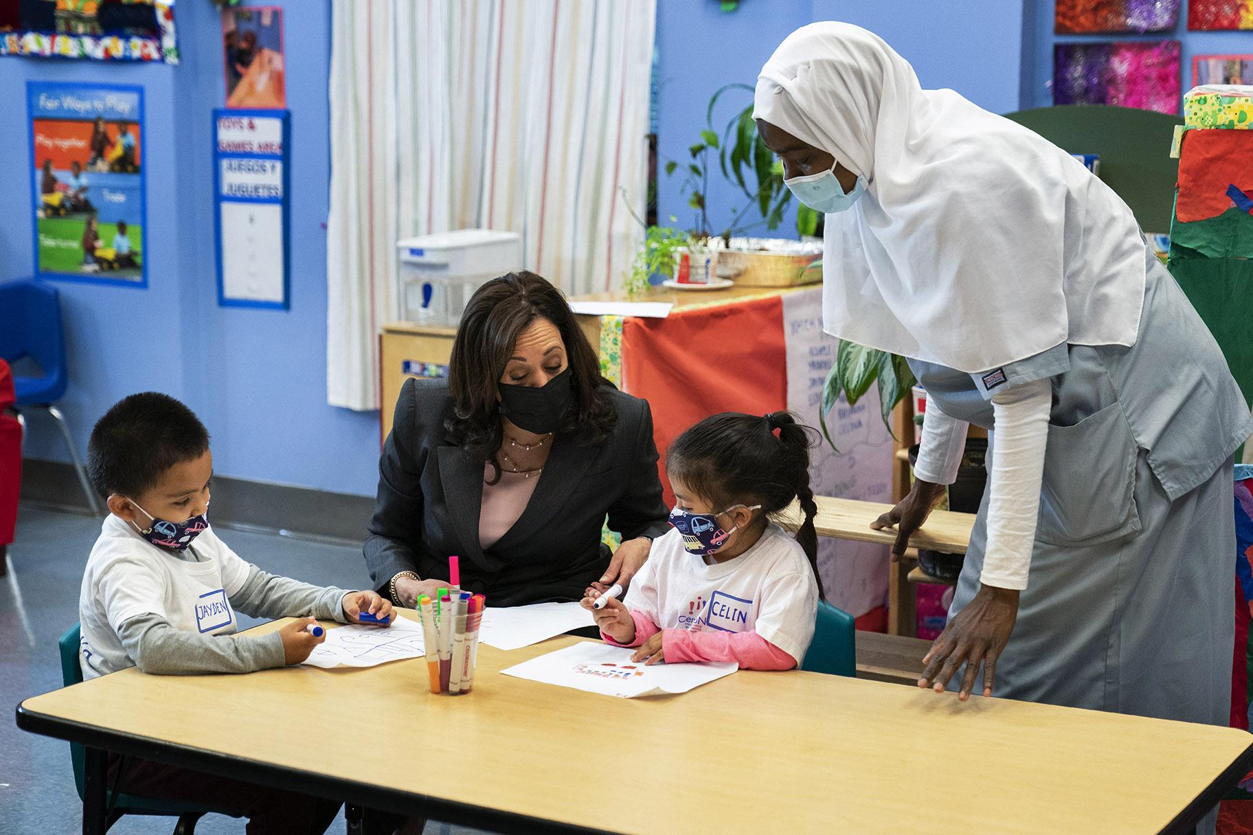 In this June 11, 2021, file photo, Vice President Kamala Harris talks with bilingual early childhood education school CentroNia students Jayden Bello, left, and Celina Barrera during a visit to the school in northwest Washington. Teacher Billo Diawara, right, watches. (AP Photo / Manuel Balce Ceneta, File)