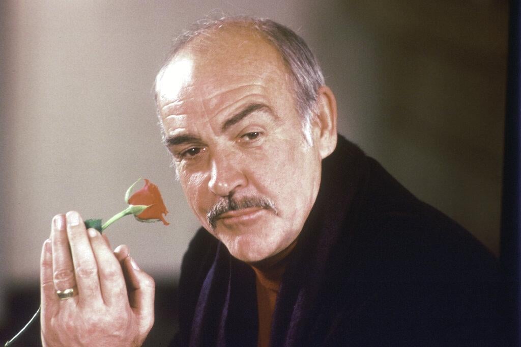 In this Jan. 23, 1987 file photo, actor Sean Connery holds a rose in his hand as he talks about his new movie “The Name of the Rose” at a news conference in London. (AP Photo / Gerald Penny, File)