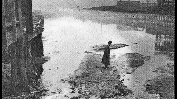 A man standing on waste in Bubbly Creek, 1911. (Wikimedia Commons)