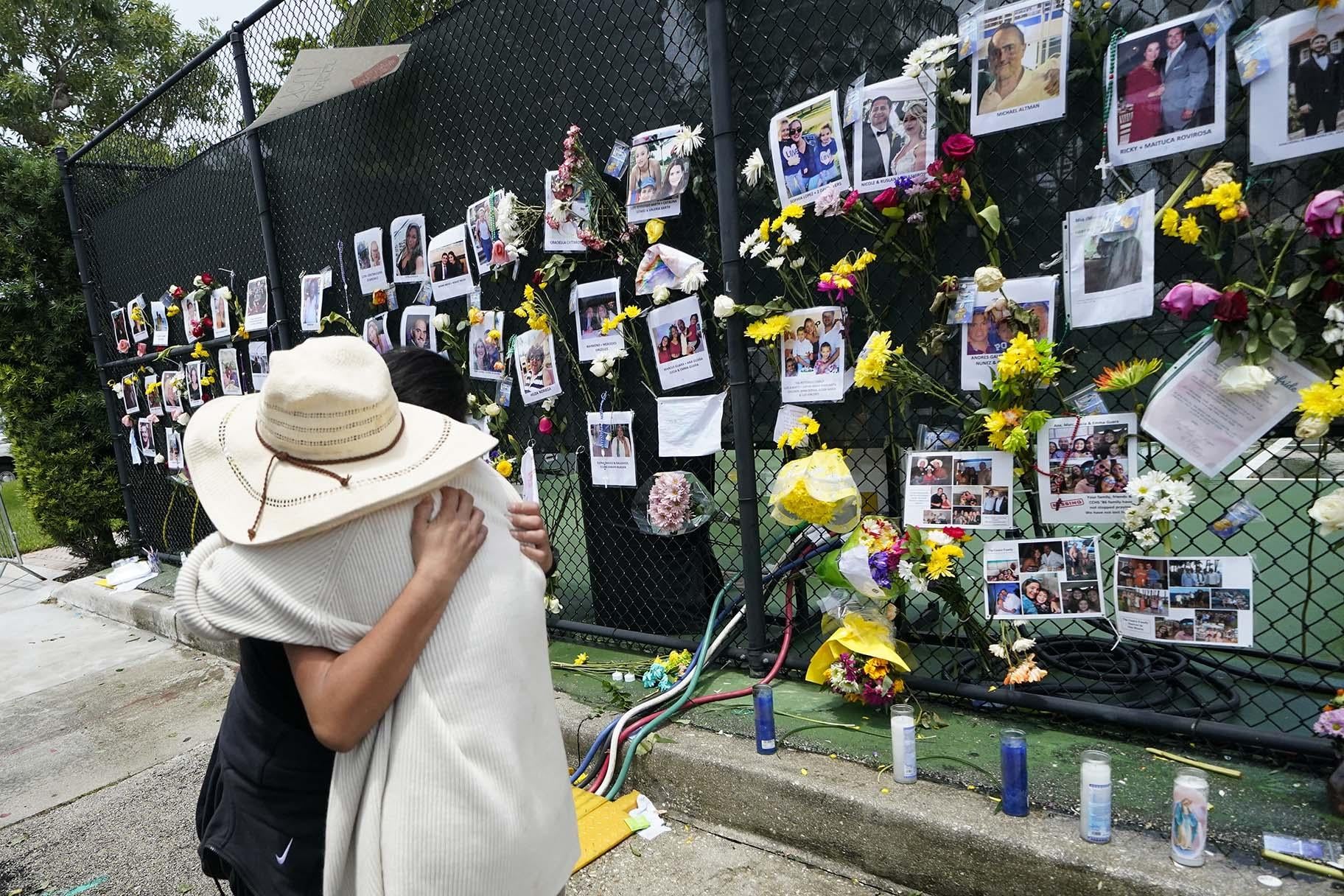 People embrace at a make-shift memorial outside St. Joseph Catholic Church, in Surfside, Fla., Monday, June 28, 2021, near the collapsed building for people still missing or dead. (AP Photo / Gerald Herbert)