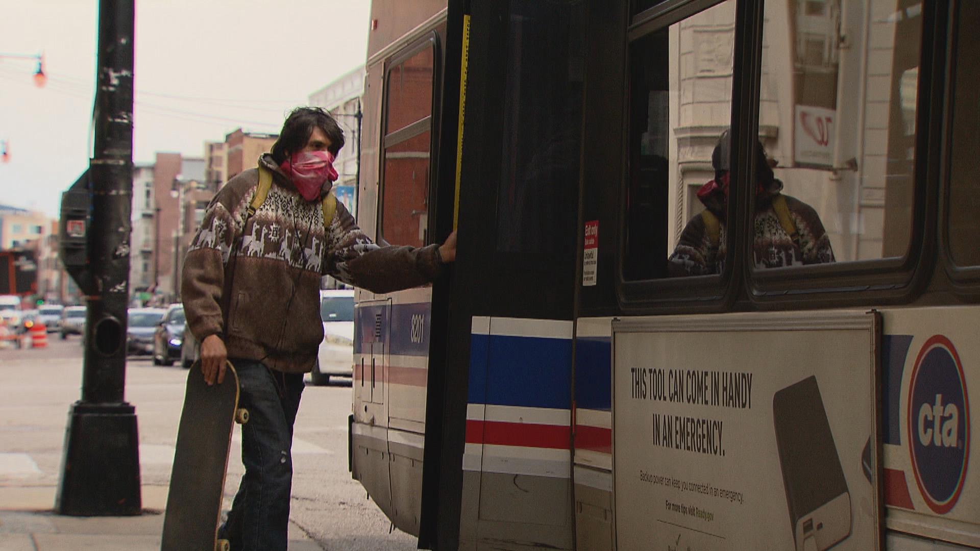 A passenger boards a CTA bus from the rear doors on Thursday, April 9, 2020. (WTTW News)
