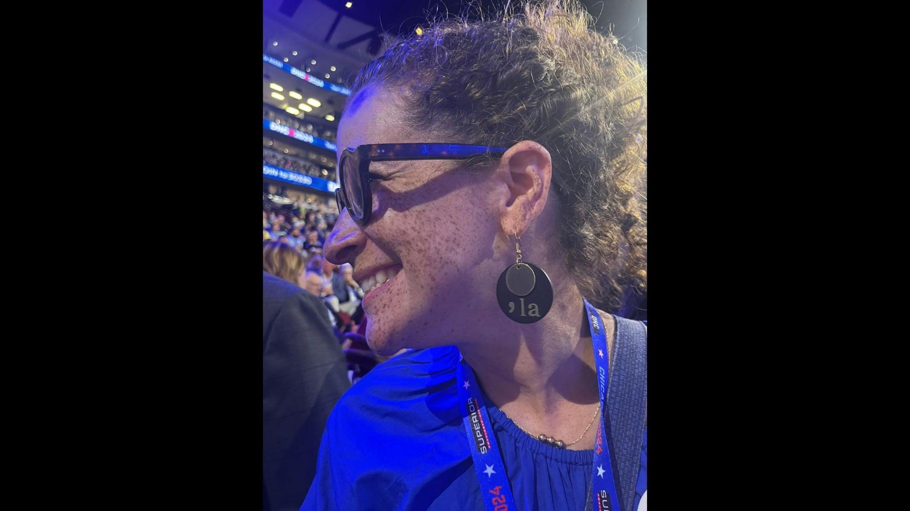 State Rep. Mary Beth Canty (D-Arlington Heights) shows off her “comma-la” earrings — a nod to the phenetic pronunciation of “Kamala” — on the DNC floor in Chicago in August 2024. (Hannah Meisel / Capitol News Illinois)