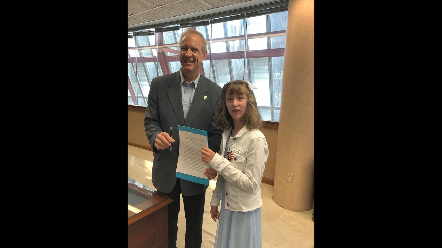 Ashley Surin with Gov. Bruce Rauner after the signing of “Ashley’s Law,” which allows children with medical cannabis licenses to bring their cannabis-derived products to school (Courtesy Jim and Maureen Surin) 