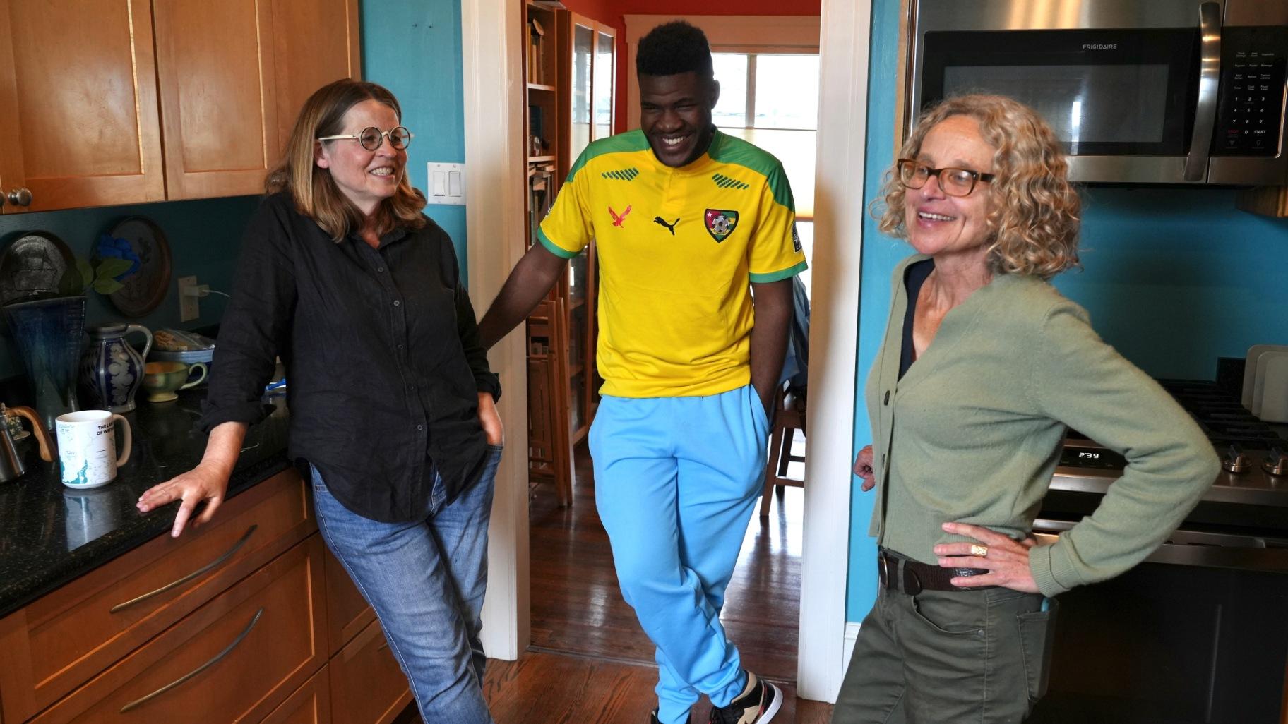 Cabrel Ngounou, center, a refugee from Cameroon, talks with his sponsors Lori Ostlund, left, and Anne Raeff in their home in San Francisco, Tuesday, Sept. 17, 2024. (Terry Chea / AP Photo)