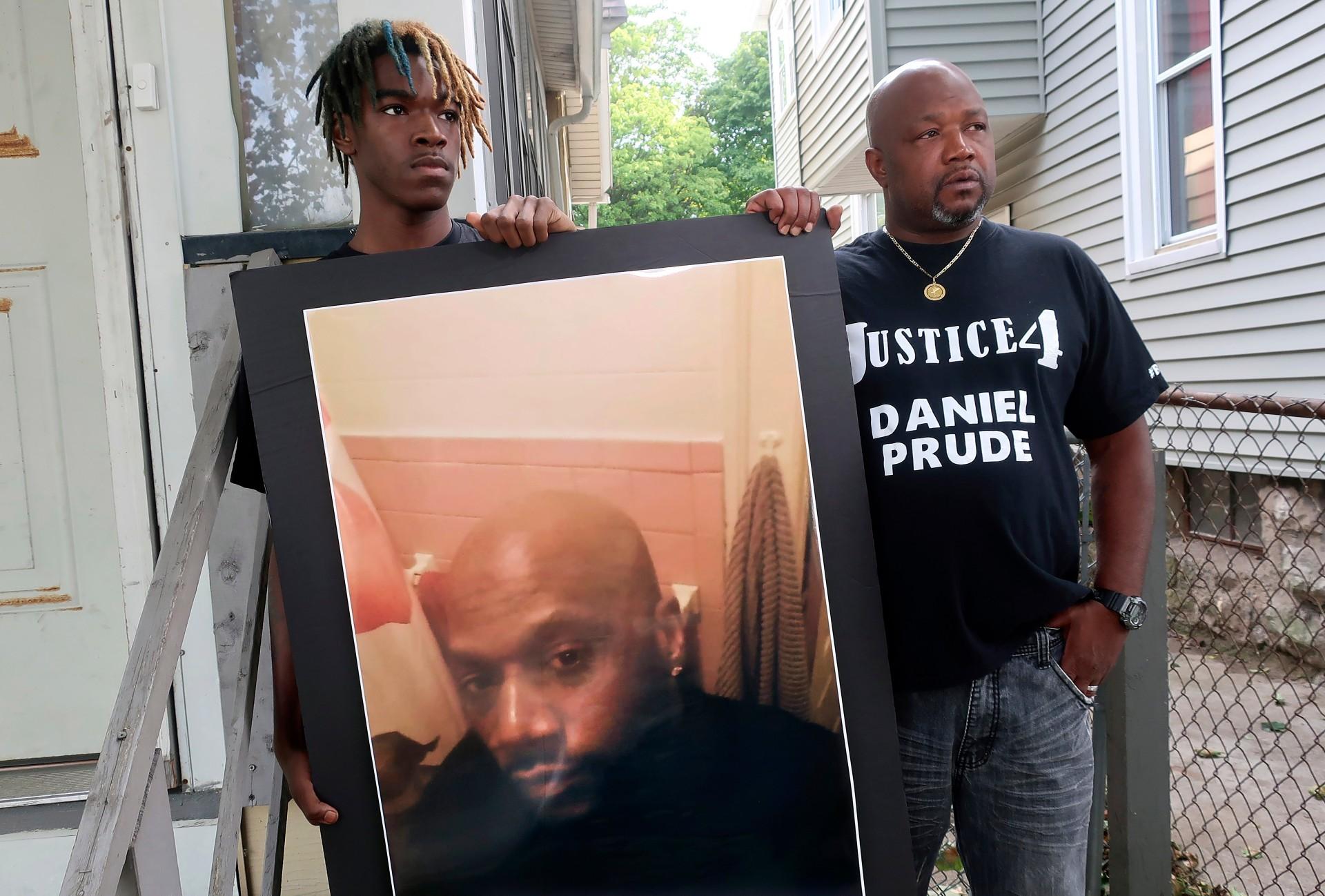 In this Sept. 3, 2020, file photo, Joe Prude, right, brother of Daniel Prude, and Daniel's nephew Armin, stand with a picture of Daniel Prude in Rochester, N.Y. (AP Photo / Ted Shaffrey, File)