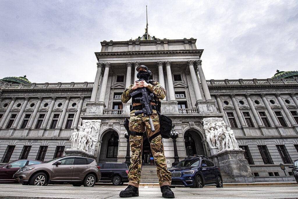 A member of the Pennsylvania Capitol Police stands guard at the entrance to the Pennsylvania Capitol Complex in Harrisburg, Pa., Wednesday, Jan. 13, 2021. (Jose F. Moreno / The Philadelphia Inquirer via AP)