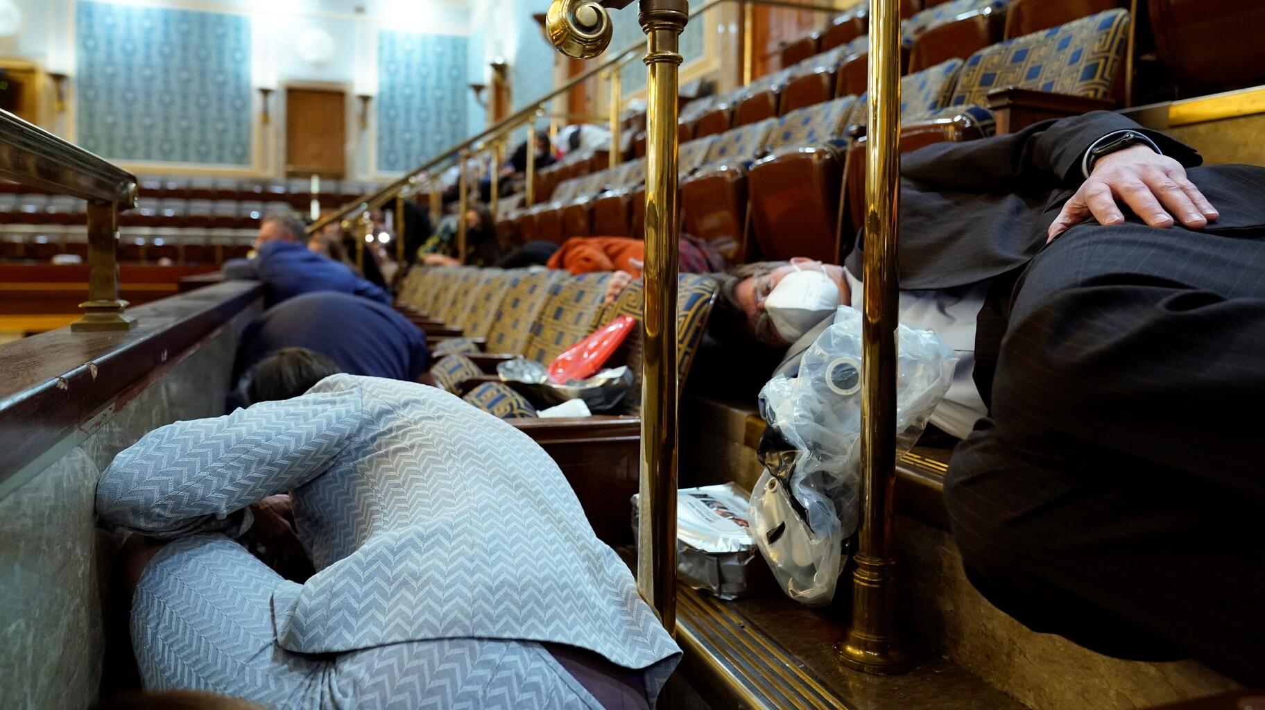 In this file photo, members of Congress and others shelter in the House gallery as rioters try to break into the House Chamber at the U.S. Capitol on Jan. 6, 2021, in Washington. (AP Photo/Andrew Harnik, File)