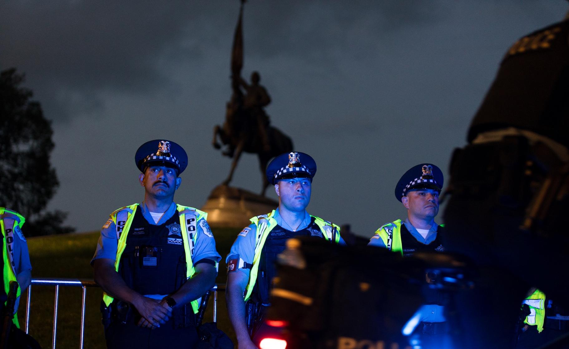 Chicago police officers line up outside Grant Park in the shadow of the monument to General Logan during protests on Aug. 18, 2024. (Michael Izquierdo / WTTW News)