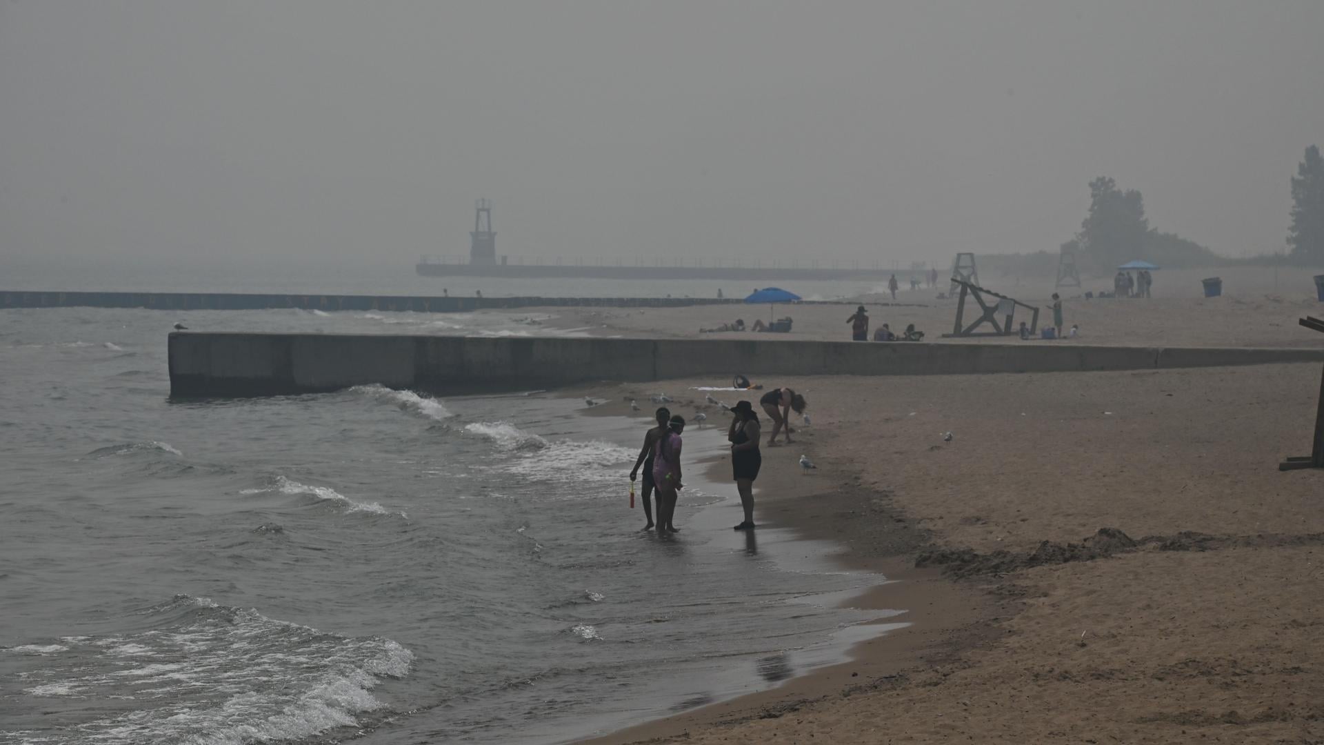 Beachgoers take a dip in Lake Michigan shortly before the Chicago Park District closed beaches for the day due to hazardous air quality on July 16, 2026. (Victor Hilitski / WTTW News)