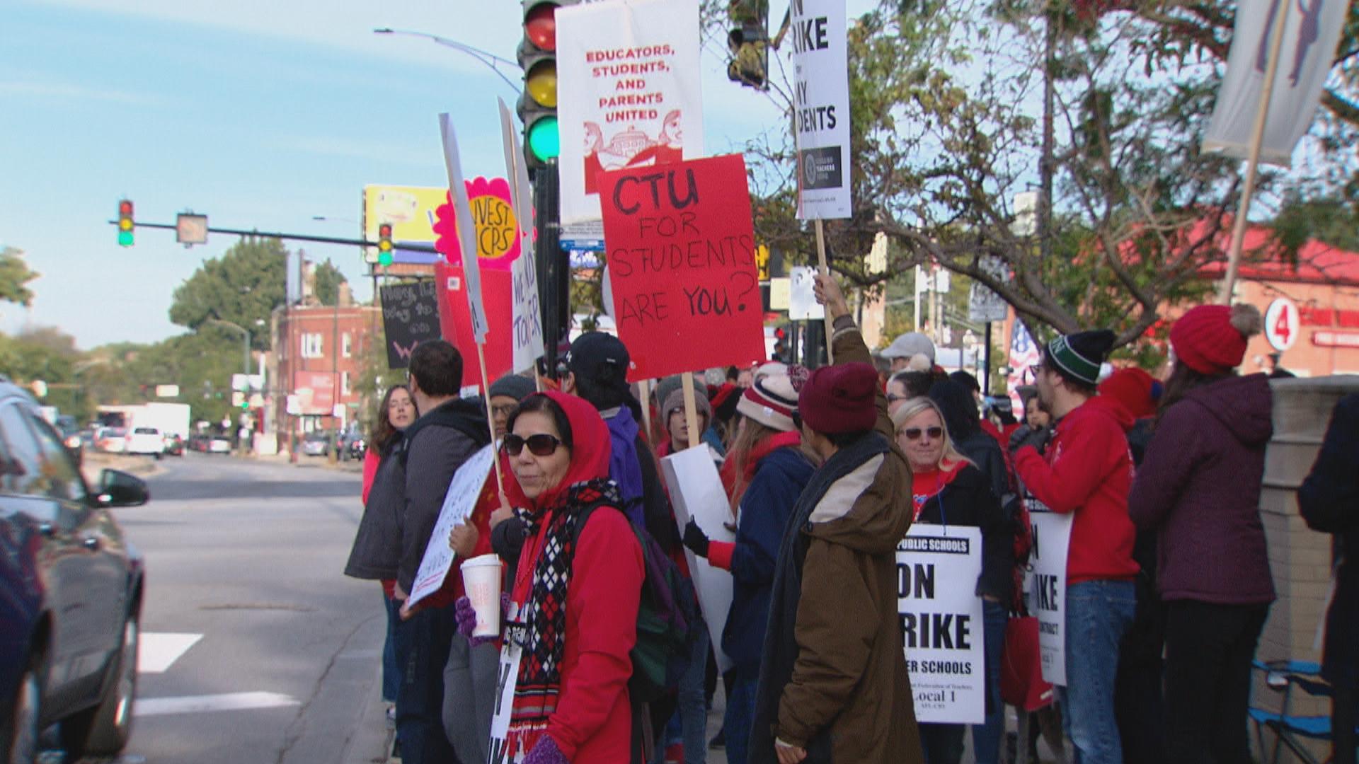 Chicago teachers hold signs and walk the picket line on day two of a strike on Friday, Oct. 18, 2019. (WTTW News)