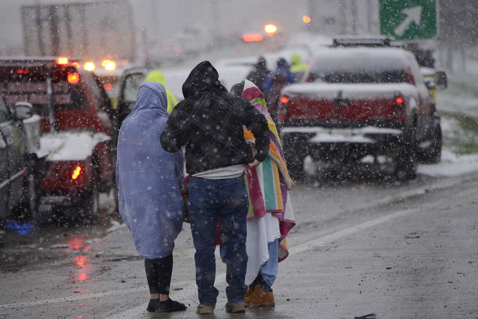 Motorists huddle together after a 54 car pile-up early morning on the Kennedy Expressway Wednesday, April 15, 2020, in Chicago. (AP Photo / Paul Beaty)