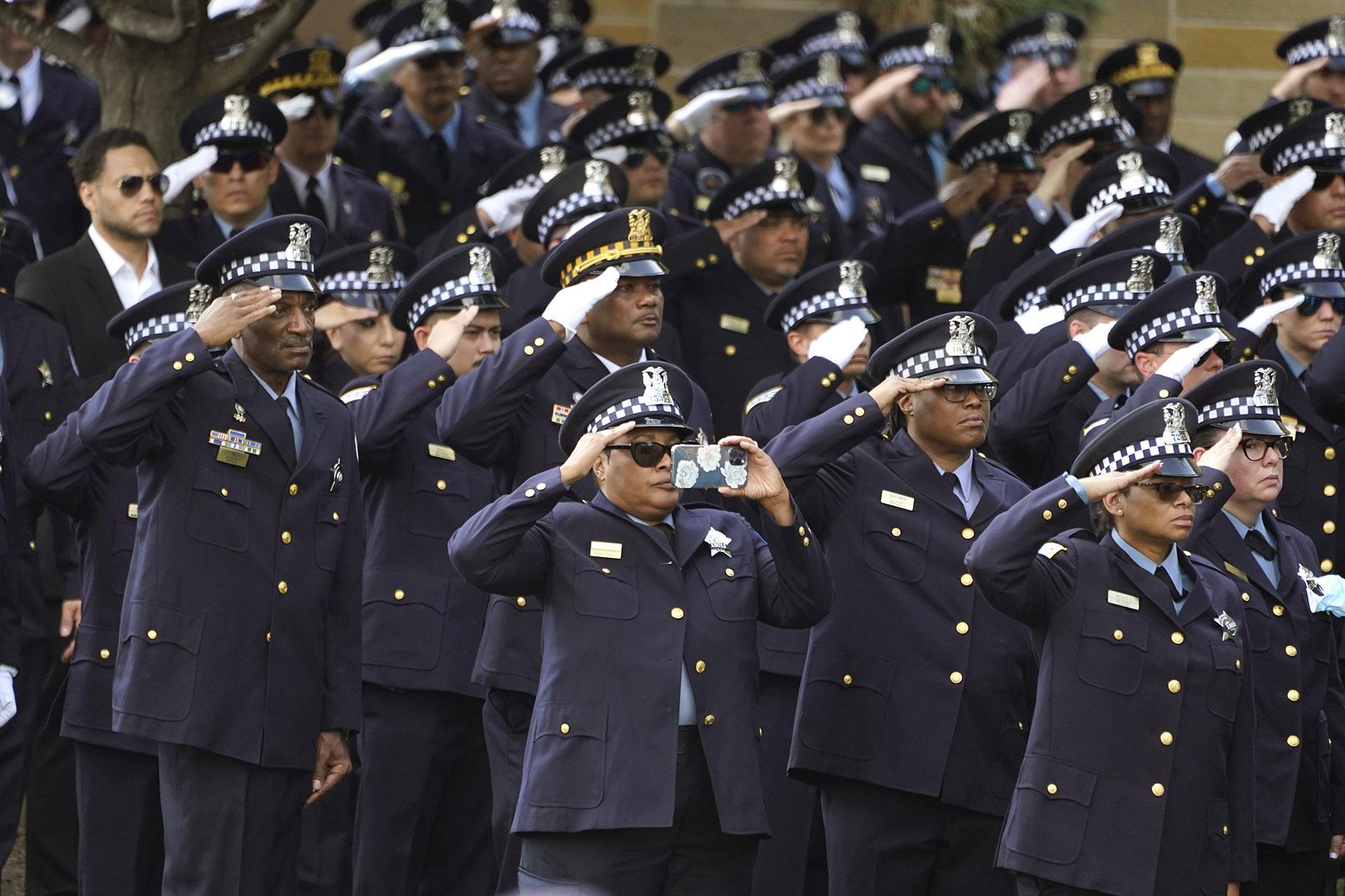 Chicago police officers salute as the body of slain Chicago police Officer Ella French is carried into the St. Rita of Cascia Shrine Chapel for a funeral service Thursday, Aug. 19, 2021, in Chicago. (AP Photo / Charles Rex Arbogast)