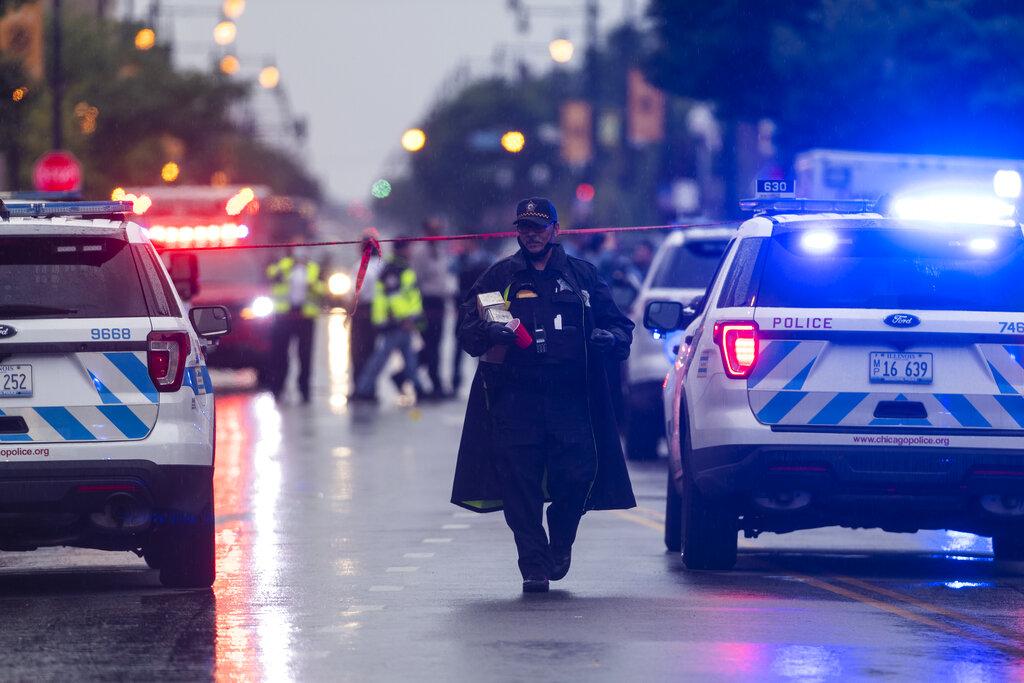 Chicago police investigate the scene of a mass shooting where more then a dozen people were shot in the Auburn Gresham neighborhood of Chicago, Tuesday, July 21, 2020. (Tyler LaRiviere / Chicago Sun-Times via AP)