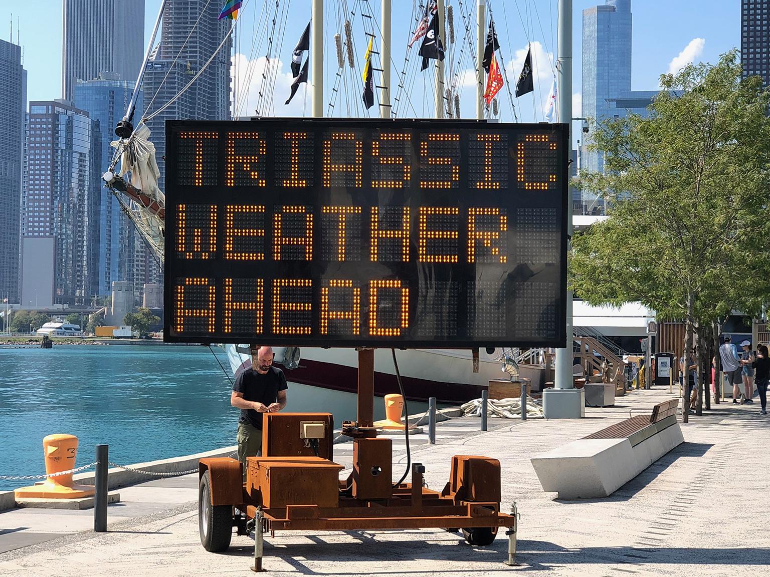 Artist Justin Brice Guariglia stands behind his new art installation “We Are the Asteroid II” on Sept. 17, 2018, at Navy Pier. (Alex Ruppenthal / Chicago Tonight)