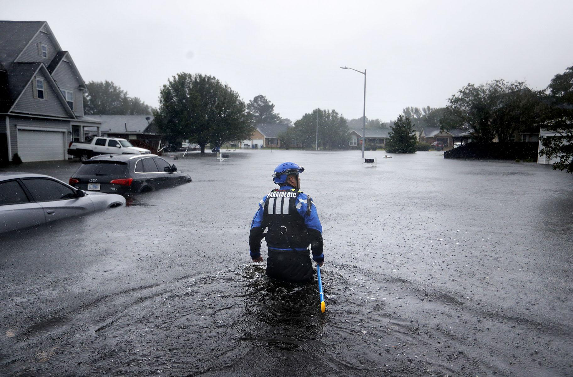 In this Sunday, Sept. 16, 2018 file photo, a member of the North Carolina Task Force urban search and rescue team wades through a flooded neighborhood looking for residents who stayed behind as Florence continues to dump heavy rain in Fayetteville, N.C. (AP Photo / David Goldman)