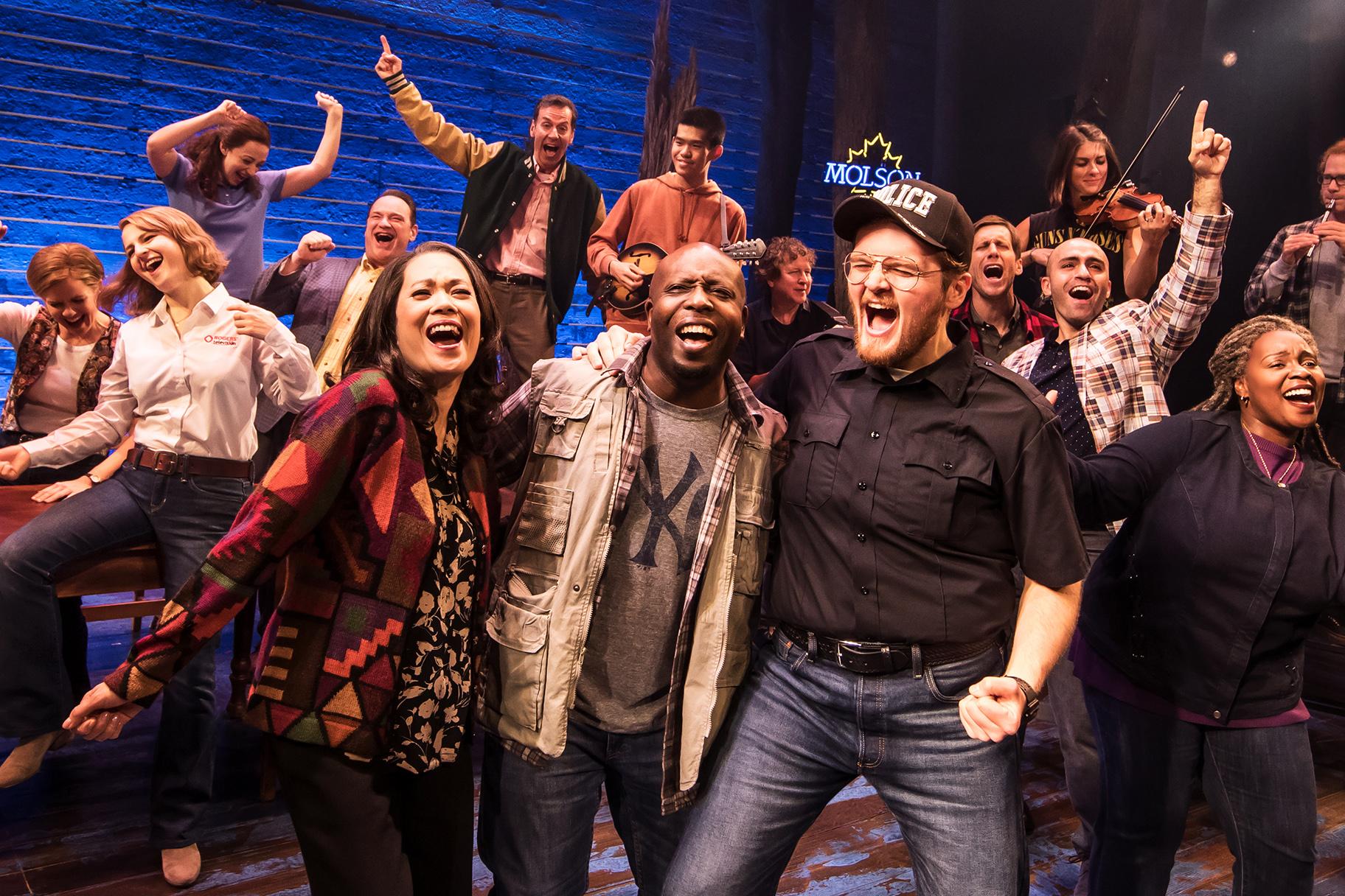 The 12-person cast in “Come From Away” easily morphs in and out of a great array of characters, from stranded travelers from many different countries (not all English-speaking) to the eccentric residents of Gander, Newfoundland, where 38 planes headed to the U.S. were ordered to land. (Photo Credit: Matthew Murphy)