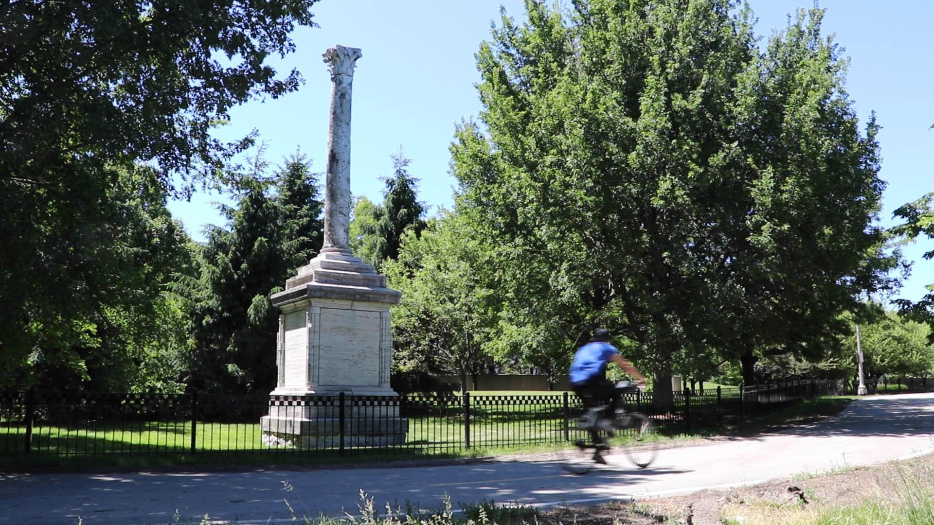 A cyclist on the lakefront trail rides past Balbo Monument, a 1933 monument gifted to the city by Italian fascist dictator Benito Mussolini. (Evan Garcia / WTTW News)