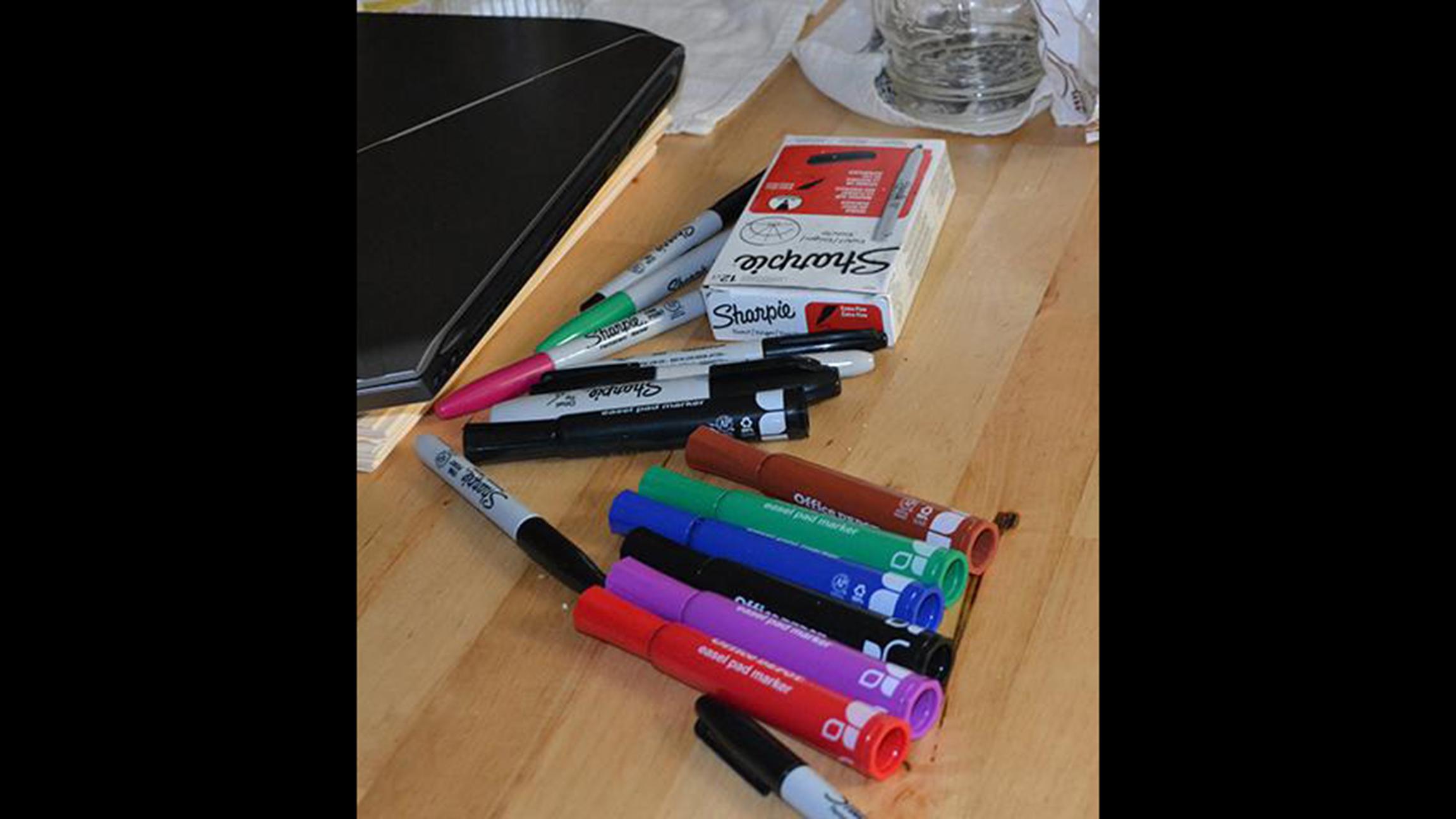 Markers, highlighters and other school supplies scattered across a kitchen table inside Franzinger Barrett's home. (Matt Masterson / Chicago Tonight)
