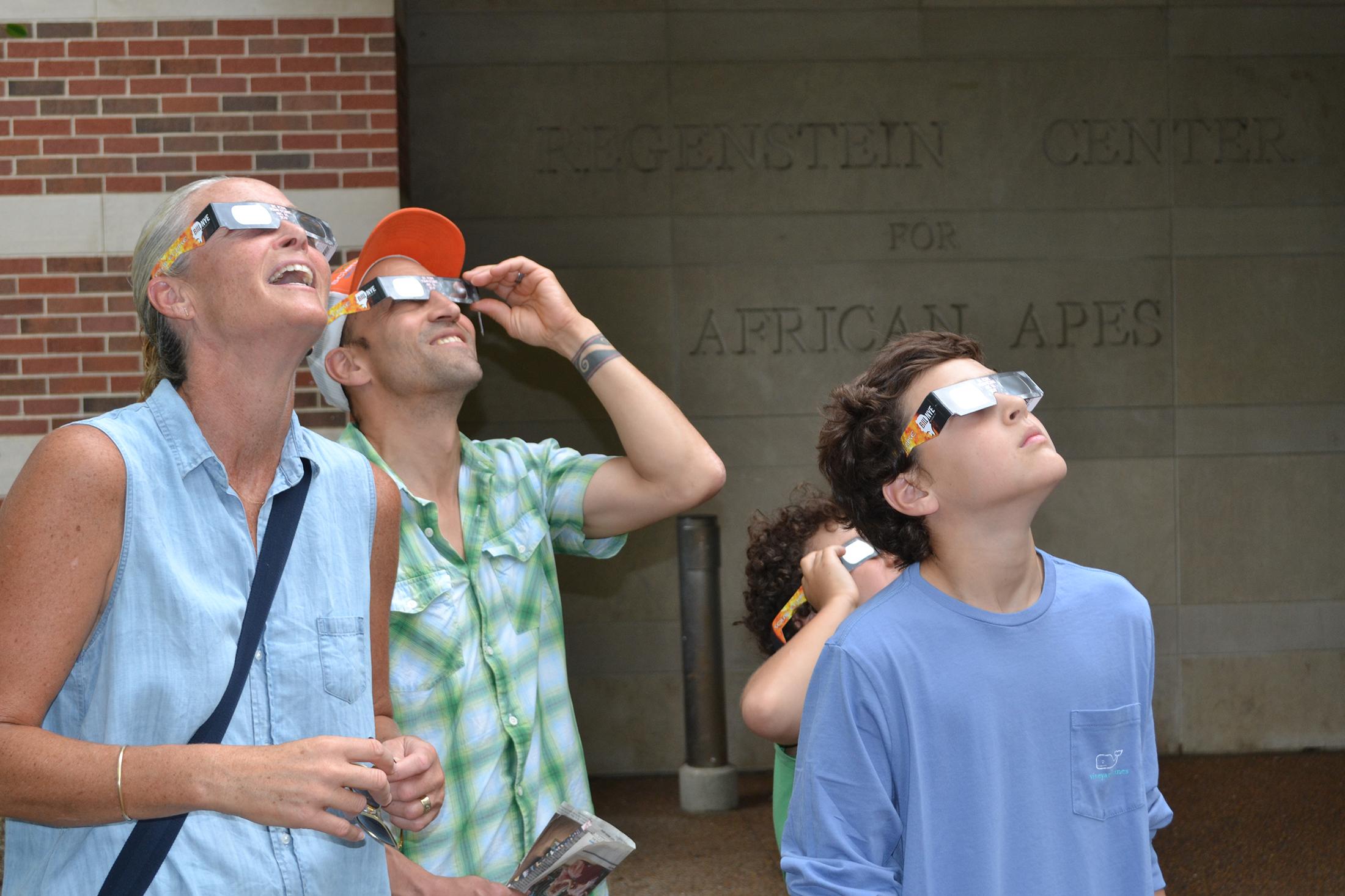 Lisa Bermudez, left, of Bend, Oregon, with husband, David, and sons Winston and Tanner, pointing their eyes to the sky during Monday's solar eclipse. (Alex Ruppenthal / Chicago Tonight)