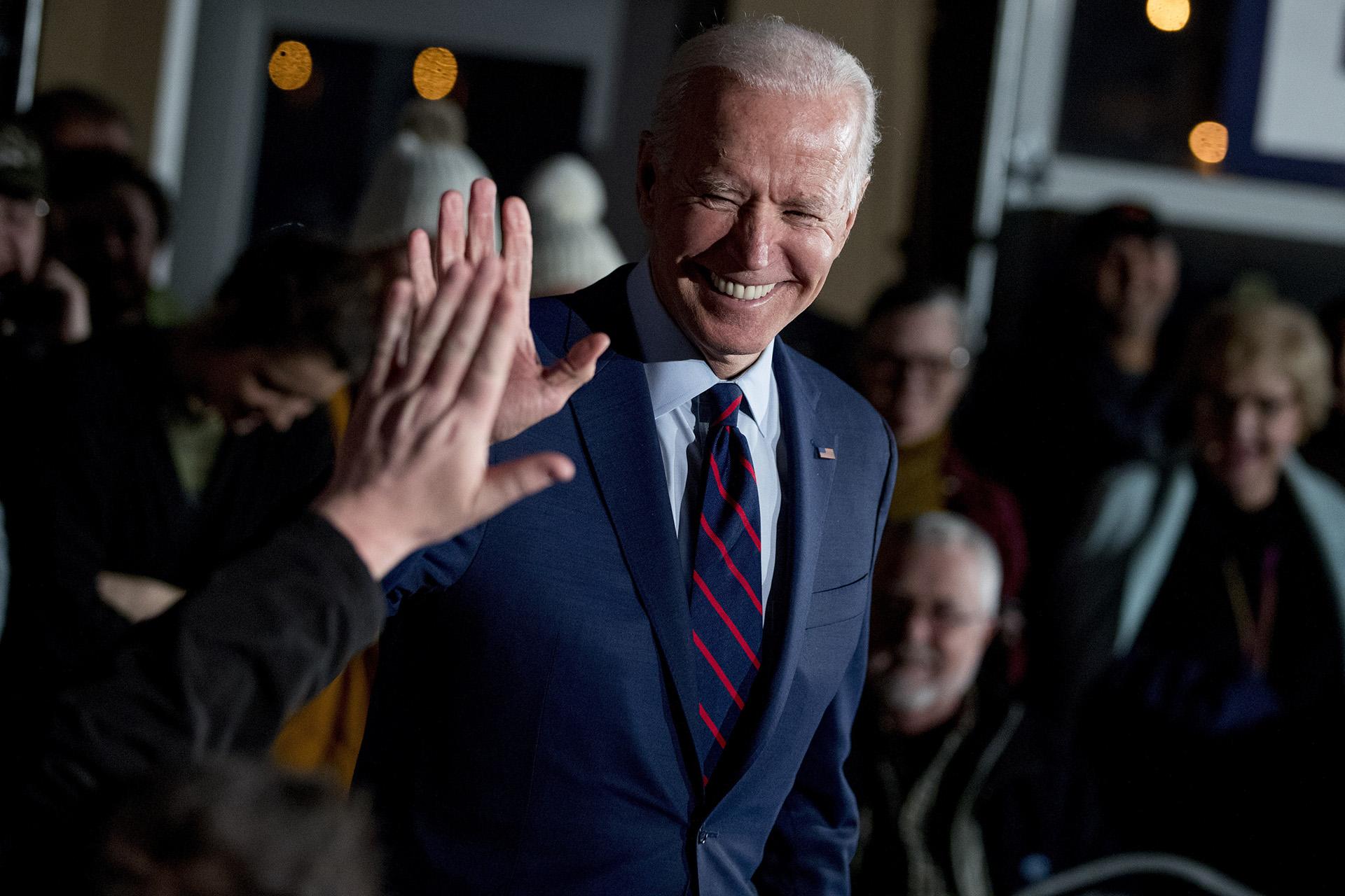 In this Jan. 5, 2020, file photo Democratic presidential candidate, former Vice President Joe Biden high-fives a member of the audience during a campaign rally at Modern Woodmen Park in Davenport, Iowa. (AP Photo / Andrew Harnik, File)