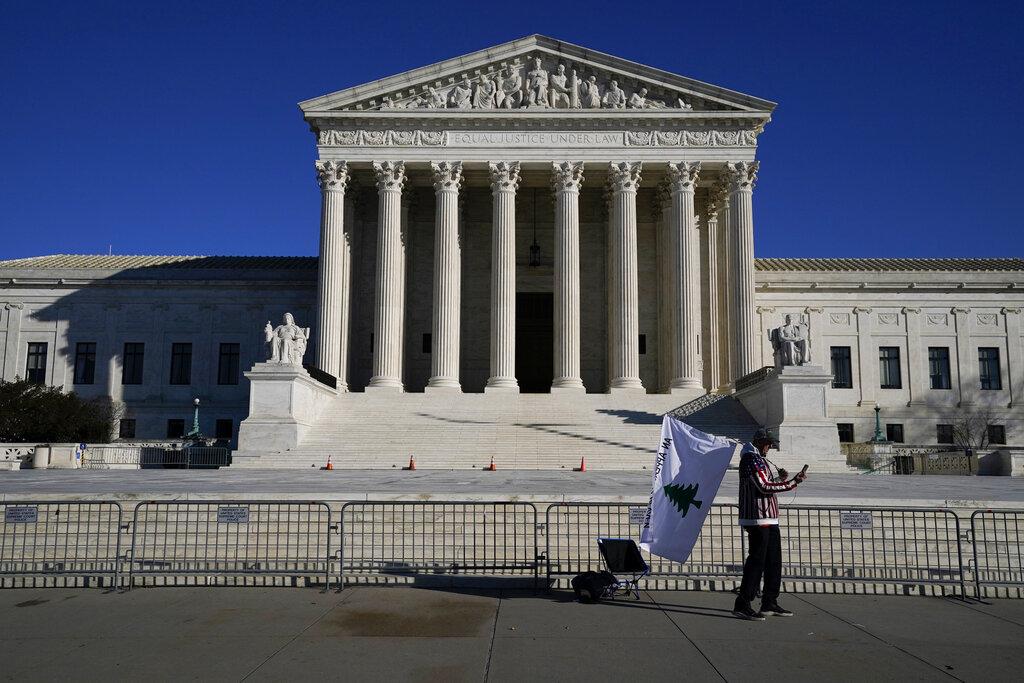 A person walks by newly-placed barricades around the Supreme Court Building, the day after violent protesters loyal to President Donald Trump stormed the U.S. Congress in Washington, Thursday, Jan. 7, 2021. (AP Photo / Evan Vucci)