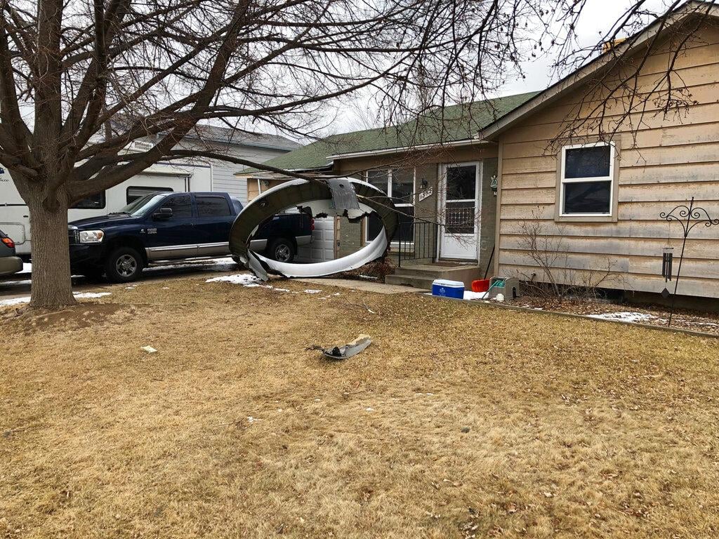 In this photo provided by the Broomfield Police Department on Twitter, debris is scattered in the front yard of a house at near 13th and Elmwood, Saturday, Feb. 20, 2021, in Broomfield, Colo. (Broomfield Police Department via AP)