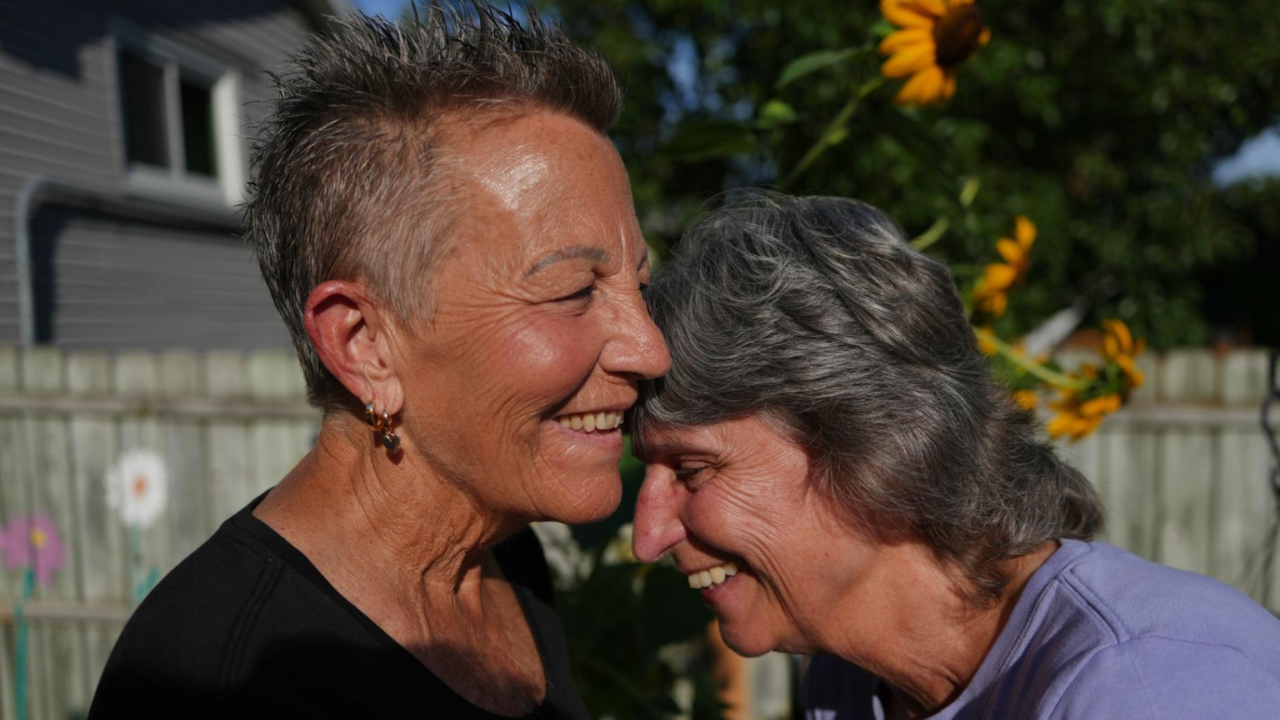 Deb Robertson, left, and her wife, Kate Koubek, laugh in the backyard of their home in Lombard, Ill., on Tuesday, Sept. 8, 2026. (AP Photo / Luis Andres Henao)