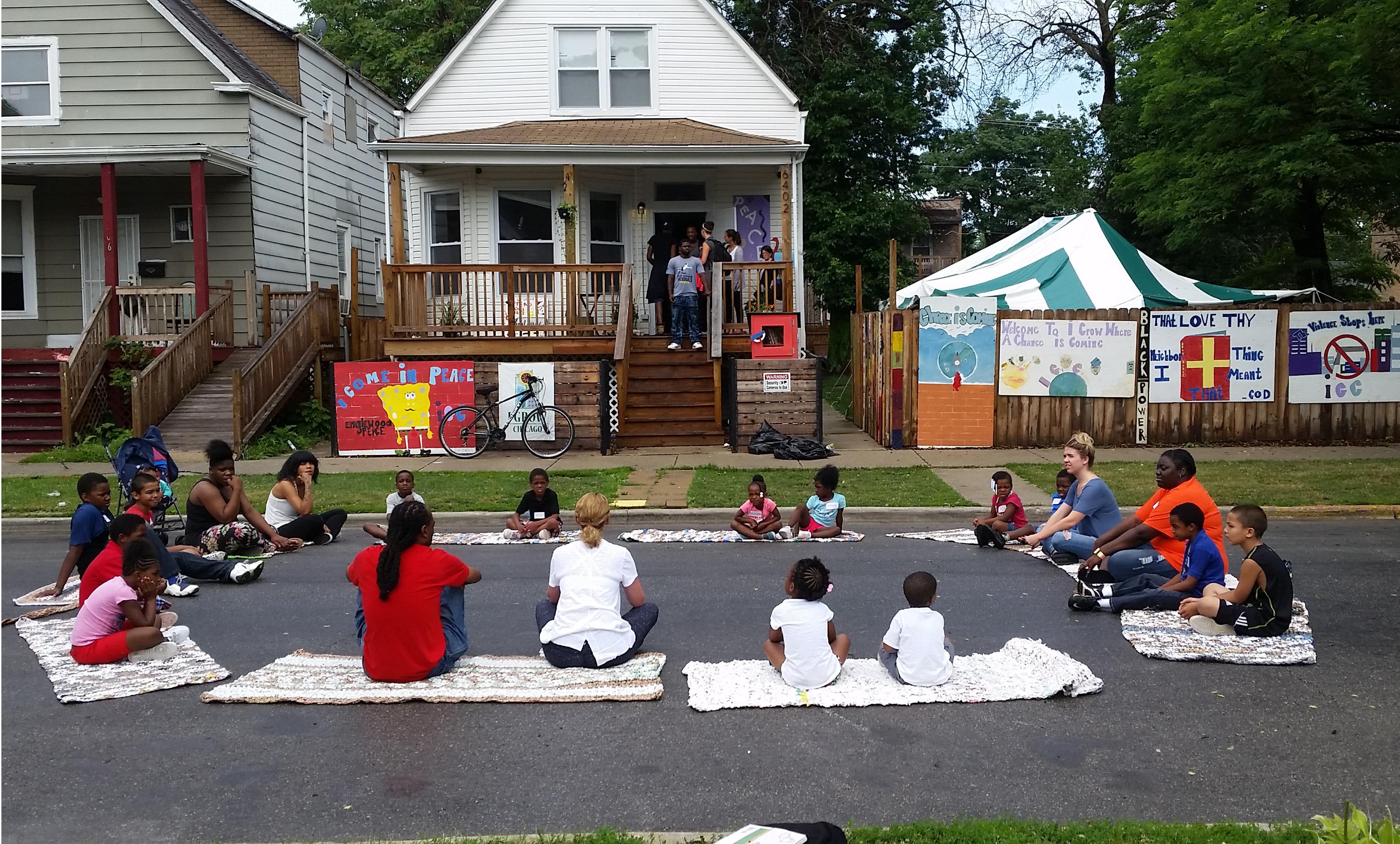 Participants take part in street yoga outside the Peace House, a community center in Englewood built by the nonprofit group I Grow Chicago. (Courtesy of Erin Vogel)