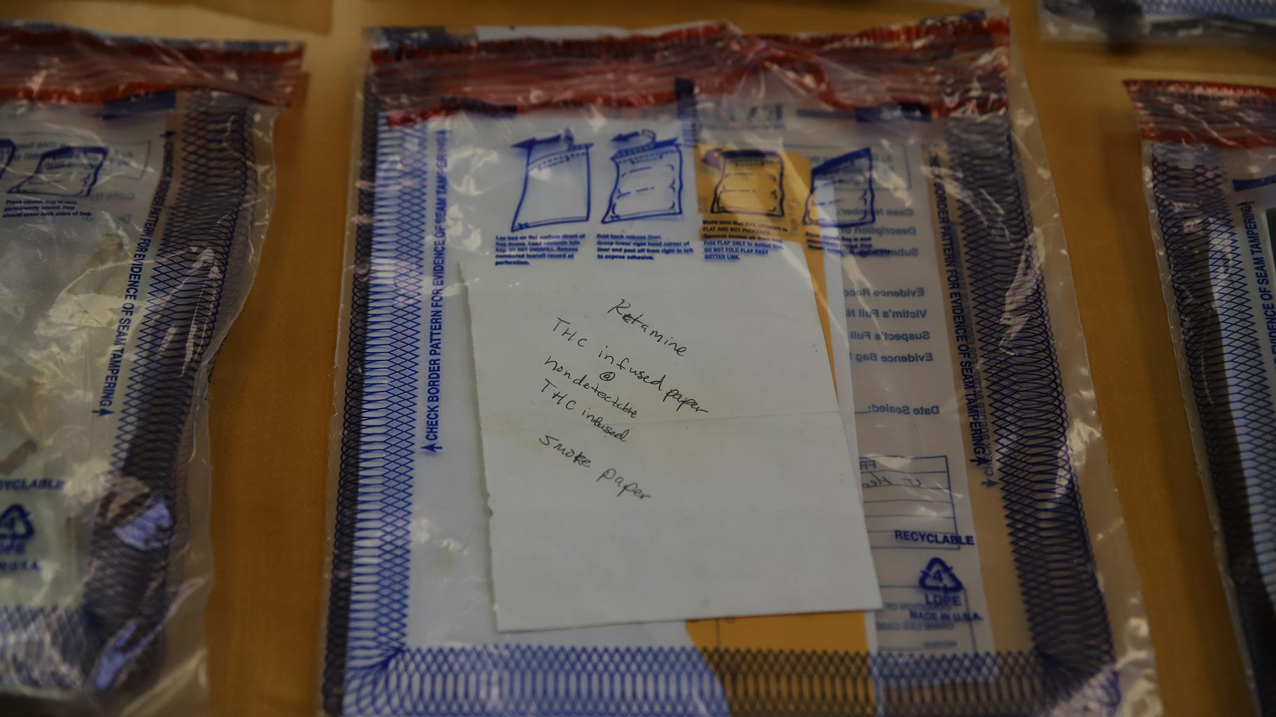Bags of evidence lay on a table at Cook County Jail on Oct. 12, 2023. One bag showed a piece of paper with instructions on how to smoke the drug soaked paper was found at one scene. (Cary Robbins / DePaul) 