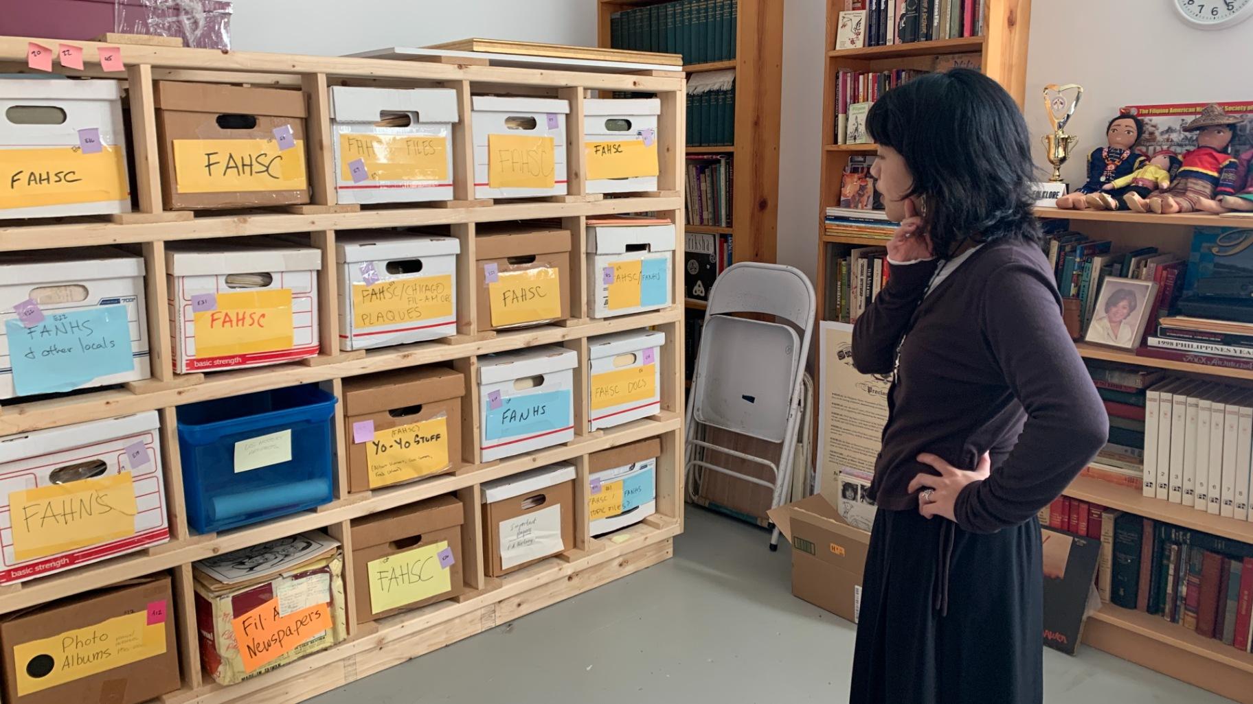 Exhibit curator and Filipino American Historical Society of Chicago board member Reese Carolina Cuison Villazor looks at the organization’s archival collection at its museum space in Mana Contemporary on Oct. 16, 2025. (Eunice Alpasan / WTTW News)