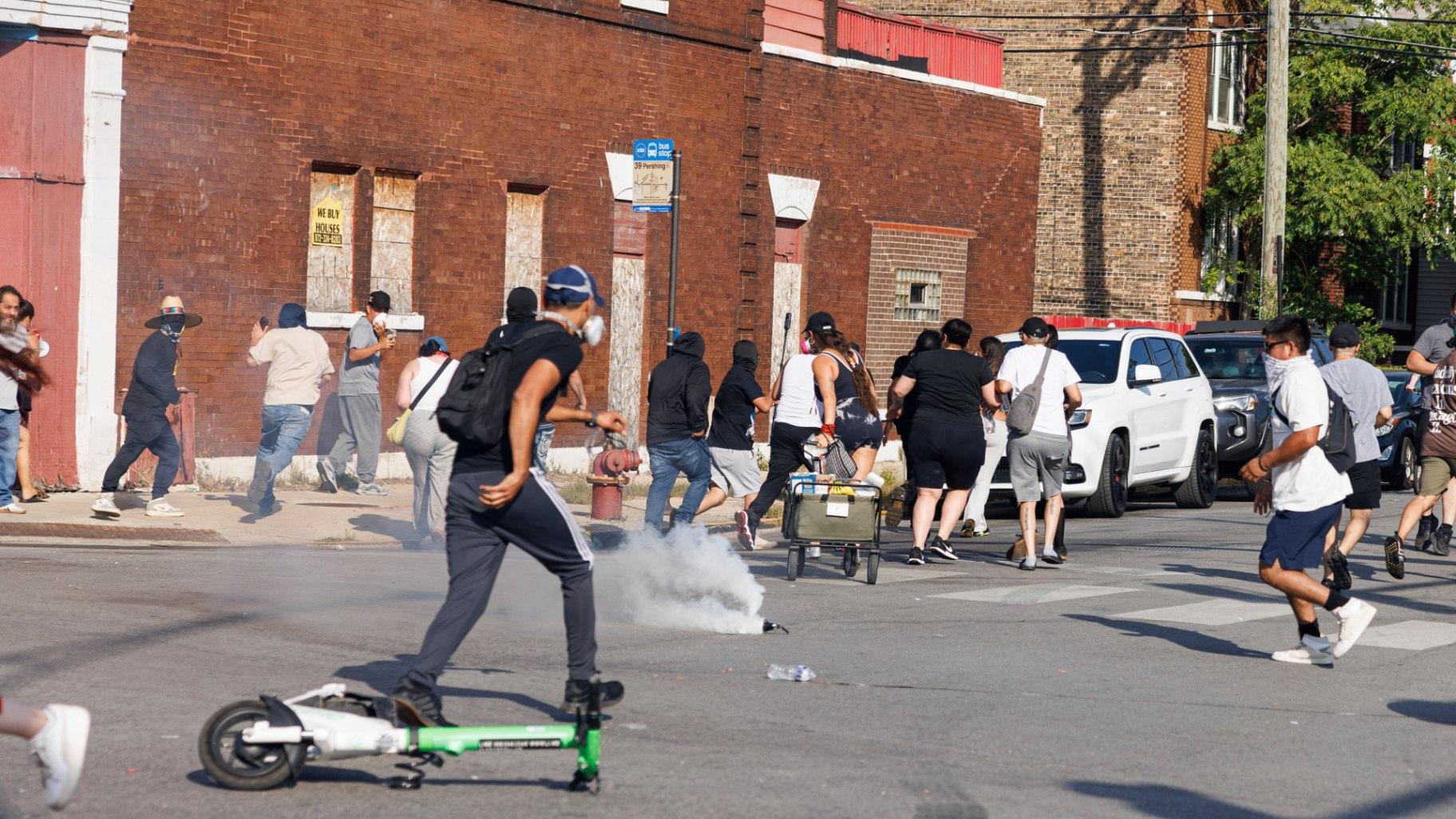 A gas canister erupts on the street in the Brighton Park neighborhood of Chicago, on Saturday, Oct. 4, 2025, after protesters learned that U.S. Border Patrol shot a woman Saturday morning on Chicago's Southwest Side. (Anthony Vazquez / Chicago Sun-Times via AP)