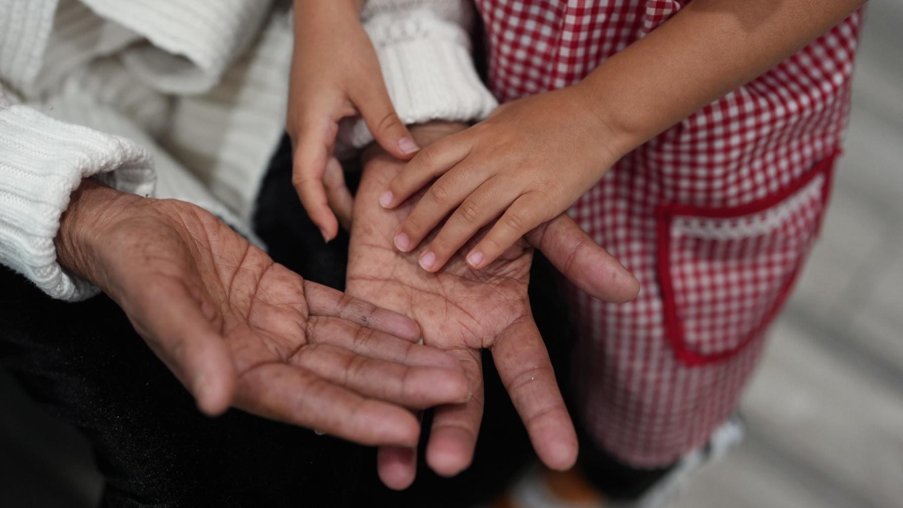 A girl touches her grandmother’s hand inside Luna y Cielo Play Cafe where children learn and practice the Spanish language through play in Chicago’s Logan Square neighborhood, Wednesday, Oct. 15, 2025. (AP Photo / Rebecca Blackwell)