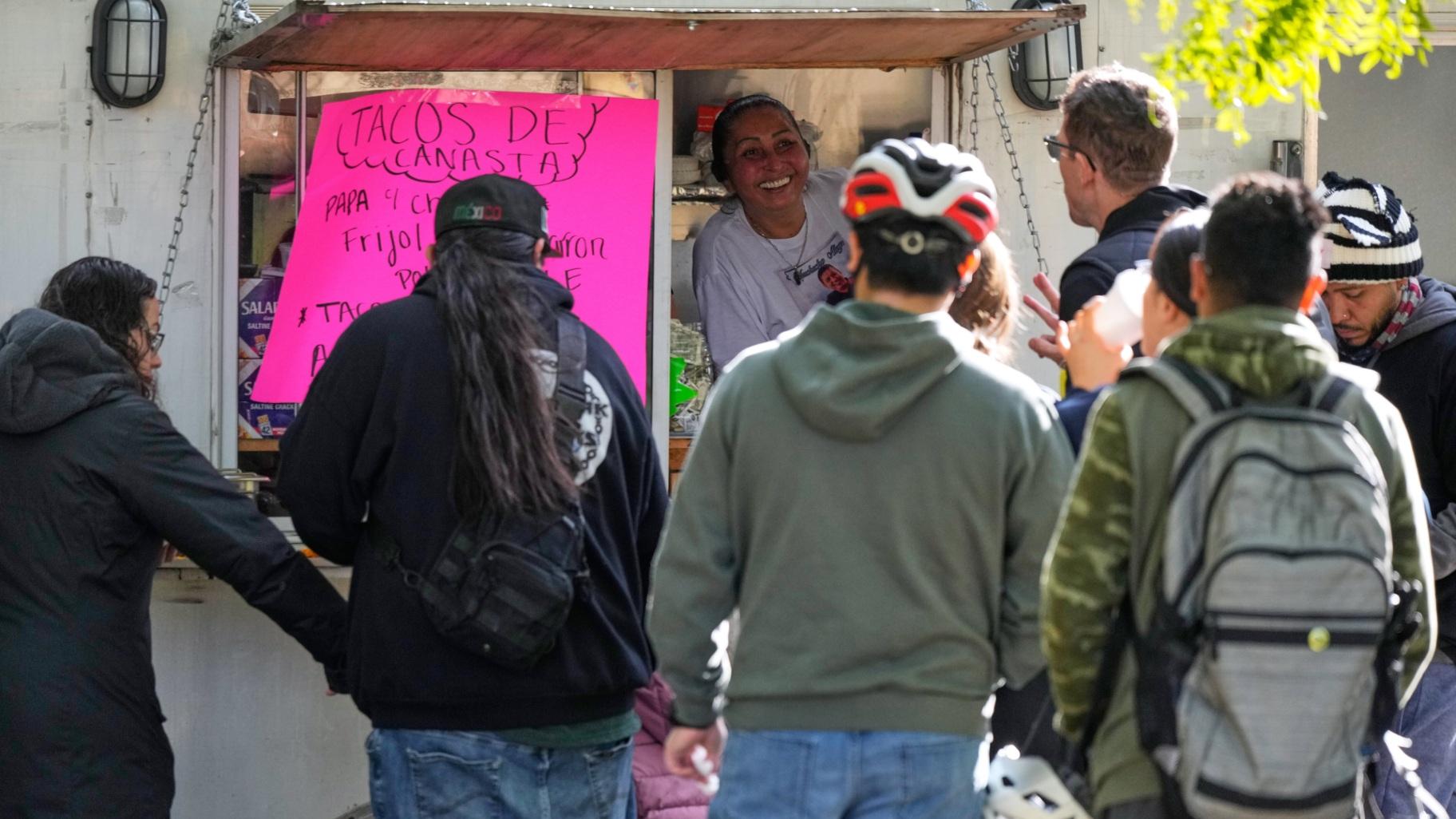 A street vendor Alicia Robles, top, takes orders from people who ride their bicycle at Gage Park during Street Vendor Bike Tour Series, in Chicago, Sunday, Nov. 2, 2025. (AP Photo / Nam Y. Huh)