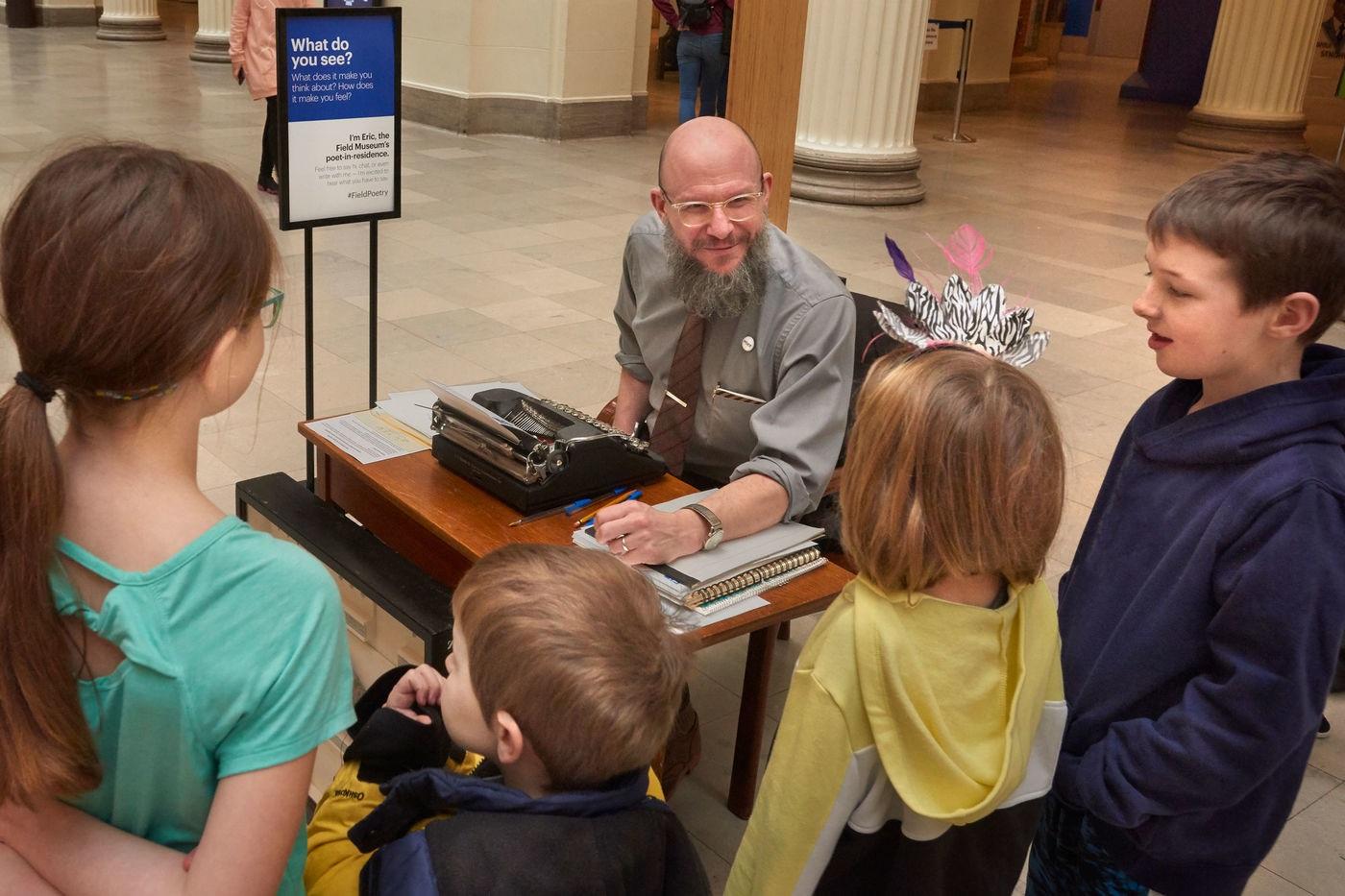 Eric Elshtain, the Field Museum’s first-ever poet-in-residence, interacts with a group of children in the museum’s Stanley Field Hall. (John Weinstein / The Field Museum)