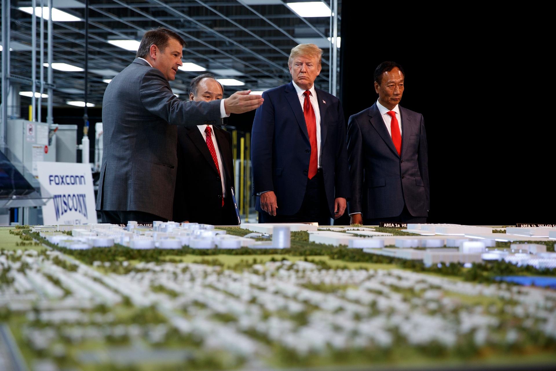 In this June 28, 2018 photo, President Donald Trump takes a tour of Foxconn with Foxconn chairman Terry Gou, right, and CEO of SoftBank Masayoshi Son in Mt. Pleasant, Wis. Foxconn Technology Group, the world's largest electronics manufacturer, has reached a new deal with reduced tax breaks for its scaled back project in southeast Wisconsin, Gov. Tony Evers and the company announced on Monday, April 19, 2021. (AP Photo / Evan Vucci, File)