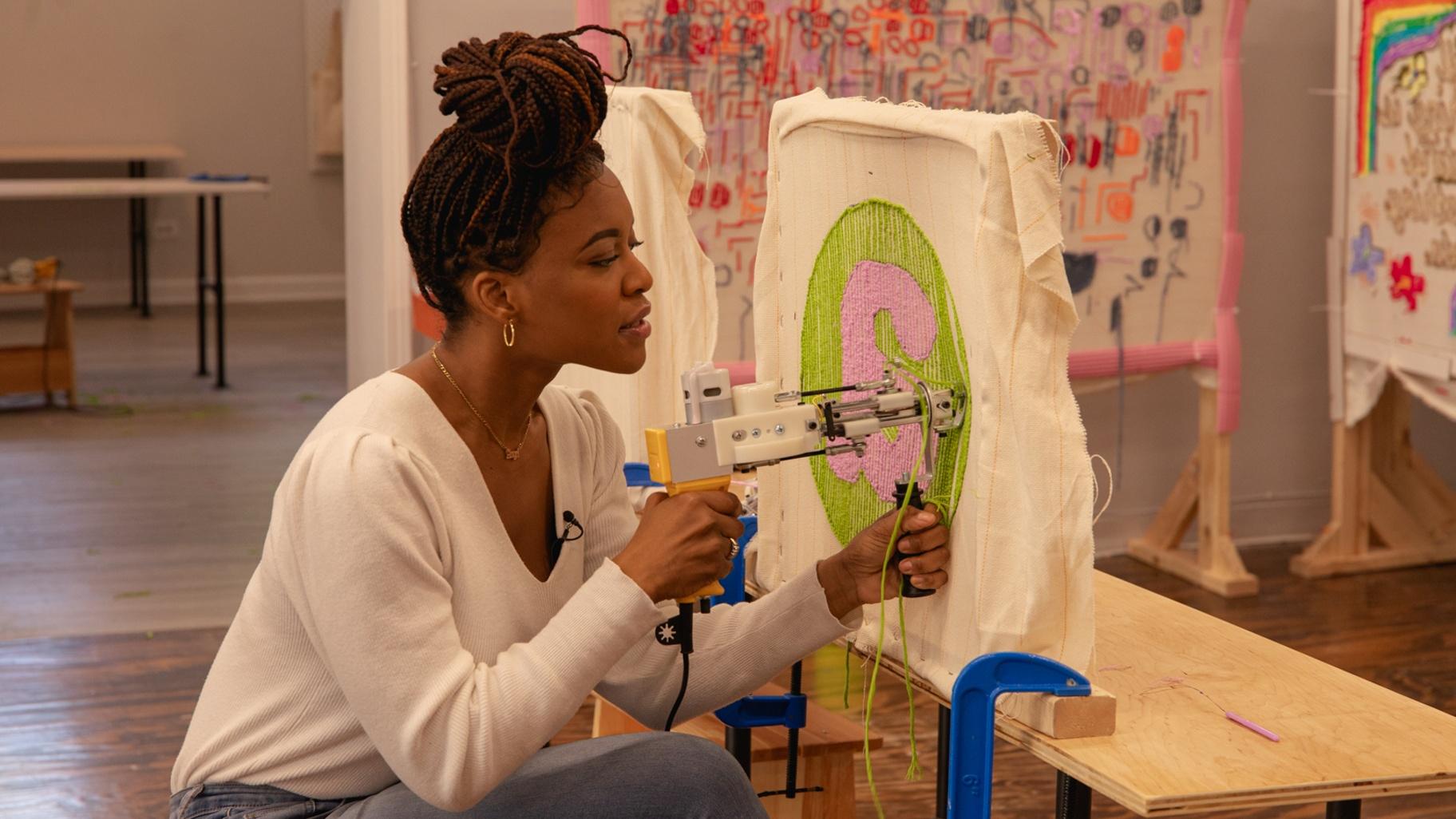 WTTW News arts correspondent Angel Idowu creates a rug at Freestyle Ceramics and Tufting. (Michael Izquierdo / WTTW News) 