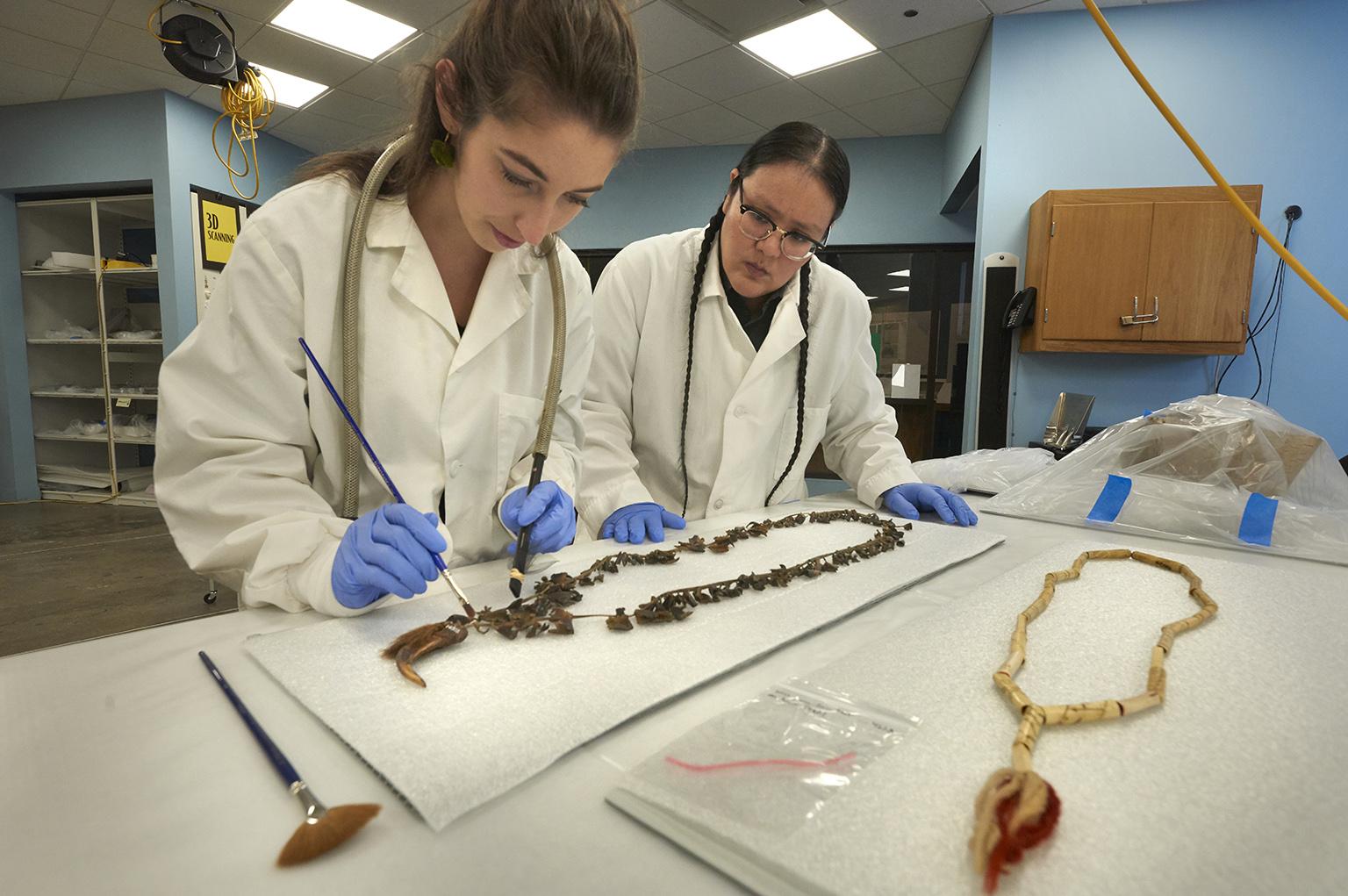 Field Museum conservation technicians Ellen Jordan and J. Kae Good Bear work on the care of cultural materials in the Regenstein Lab. (© Field Museum, photo by John Weinstein)