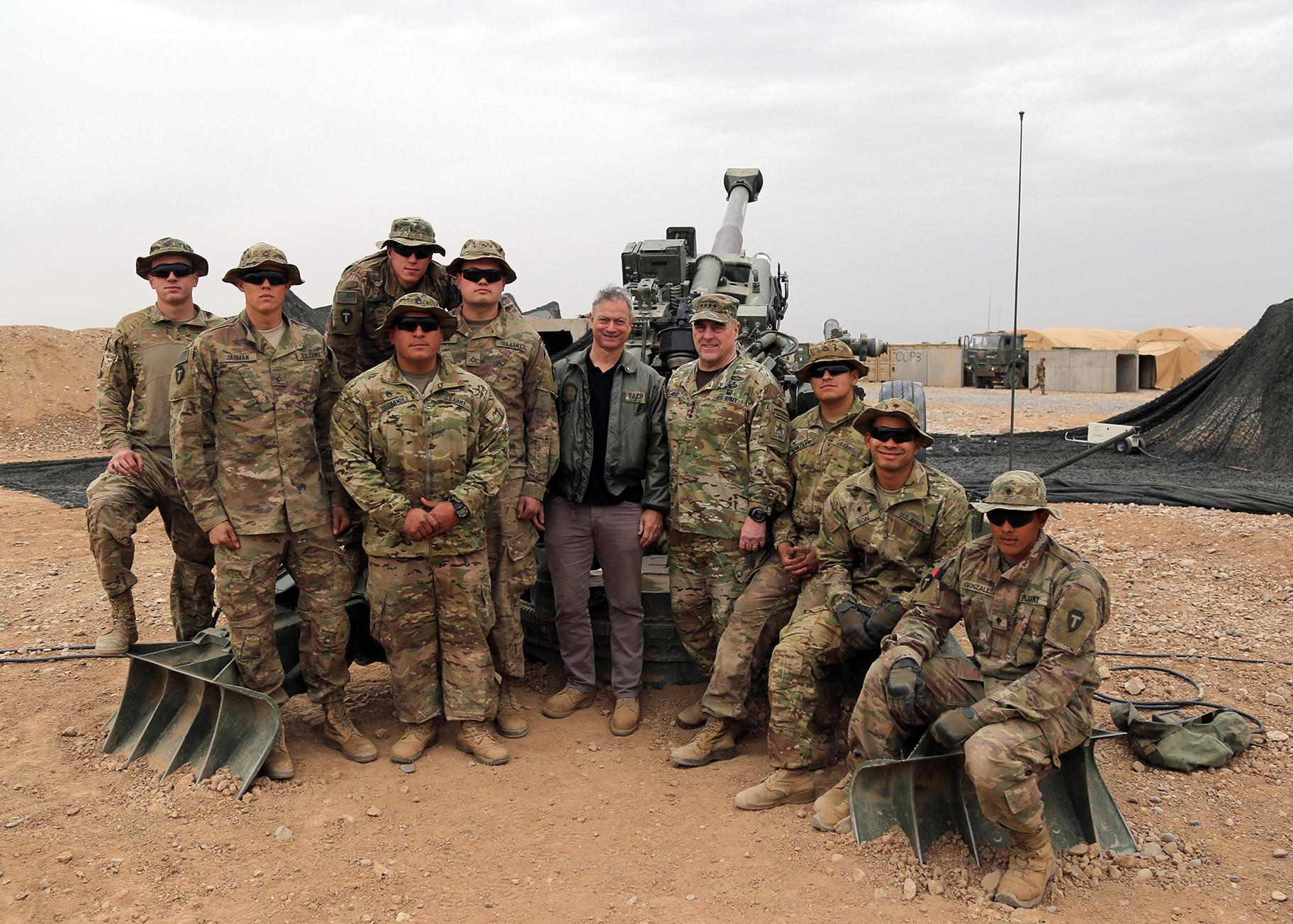 Sinise posing for a photo with members of the U.S. military. 