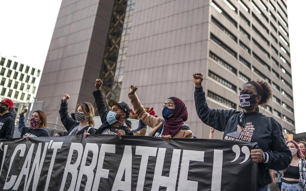 Demonstrators marched past the Hennepin County Government Center one day before jury selection is set to begin in the trial of former Minneapolis officer Derek Chauvin, who is accused of killing George Floyd Sunday, March 7, 2021, in Minneapolis, Minn. (Jerry Holt / Star Tribune via AP)