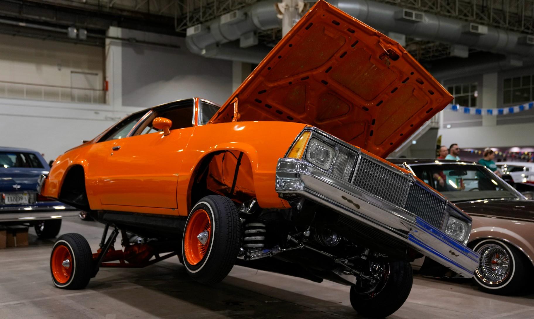 An orange lowrider car is on display at the Slow & Low Chicago Lowrider Festival, Saturday, Oct. 12, 2024, at Navy Pier in Chicago. (AP Photo/Erin Hooley)