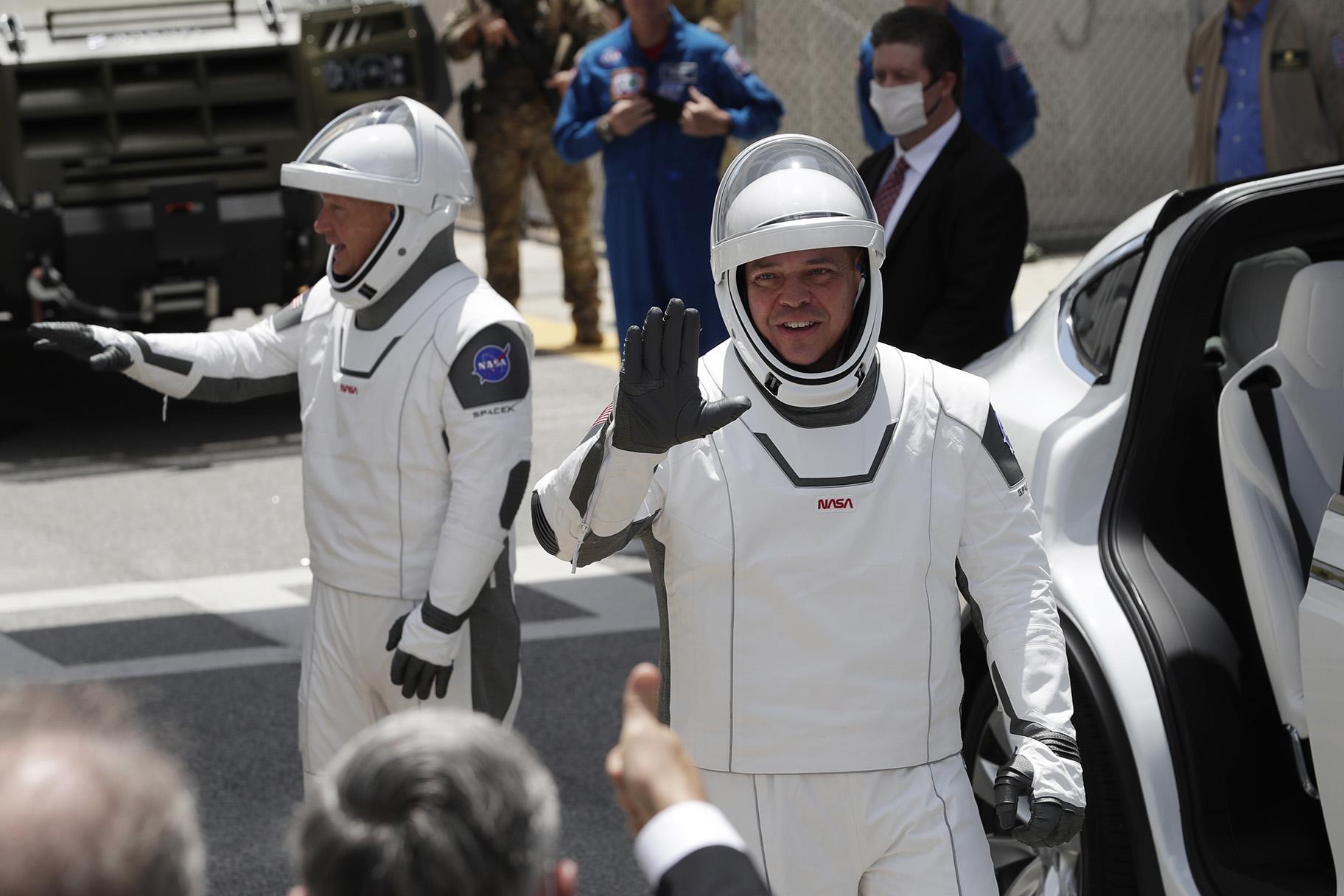 NASA astronauts Douglas Hurley, left, and Robert Behnken wave as they exit the Neil A. Armstrong Operations and Checkout Building on their way to Pad 39-A, at the Kennedy Space Center in Cape Canaveral, Fla., Saturday, May 30, 2020. (AP Photo / John Raoux)